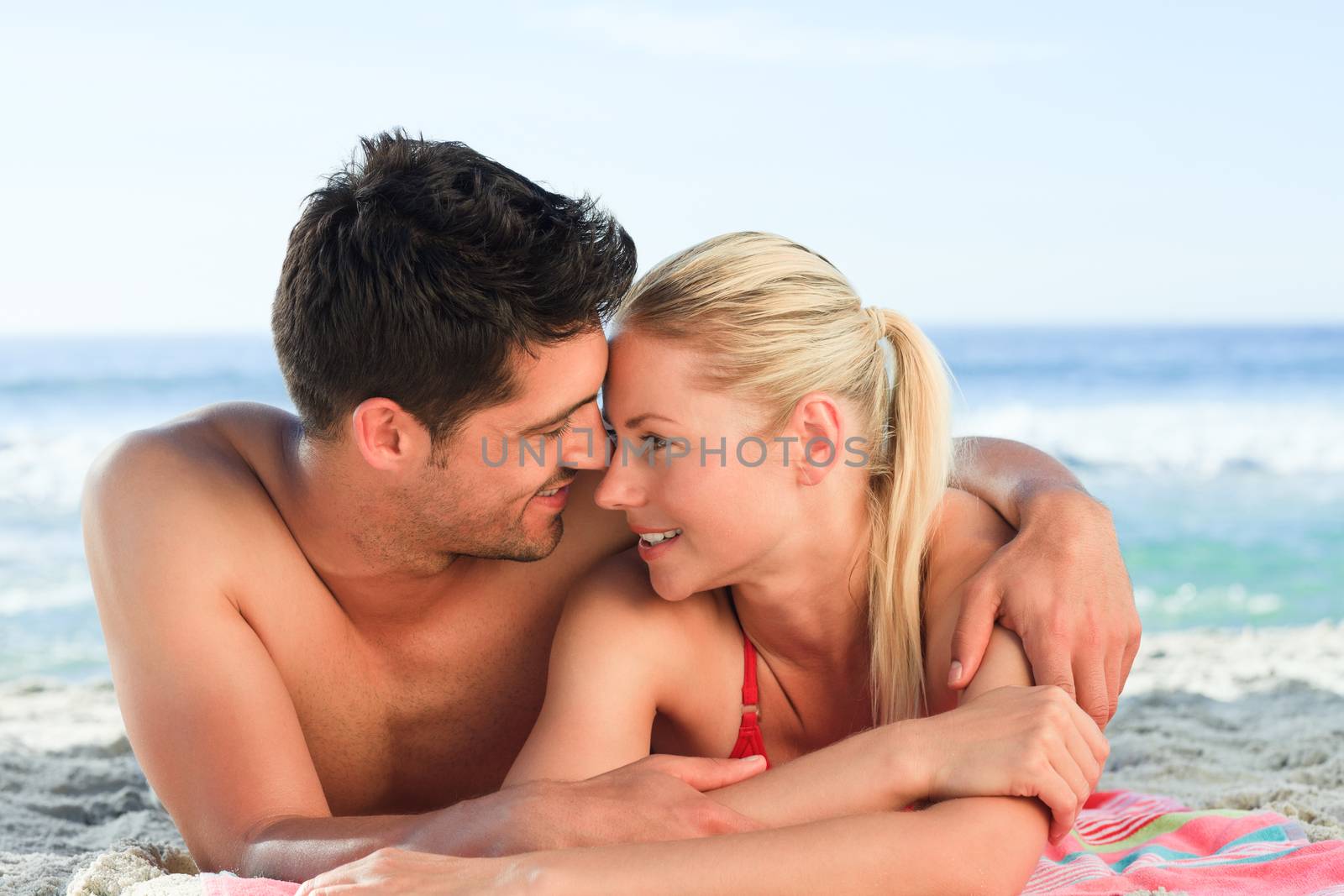 Lovers lying down on the beach by Wavebreakmedia