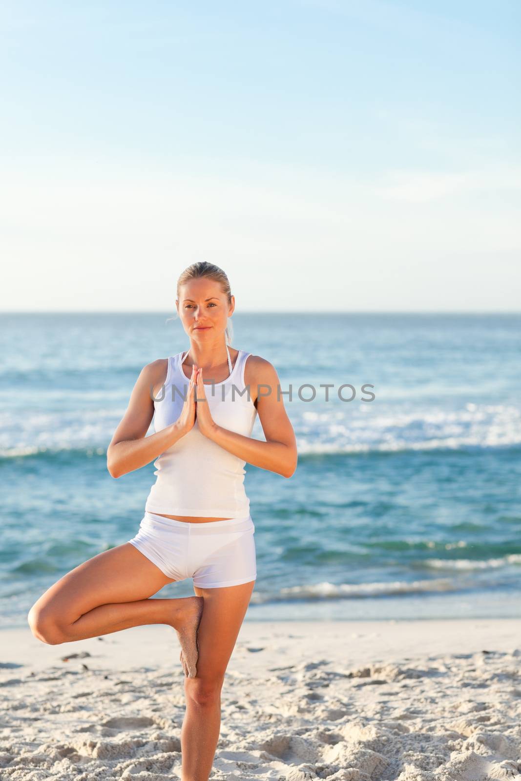 Woman practicing yoga on the beach by Wavebreakmedia