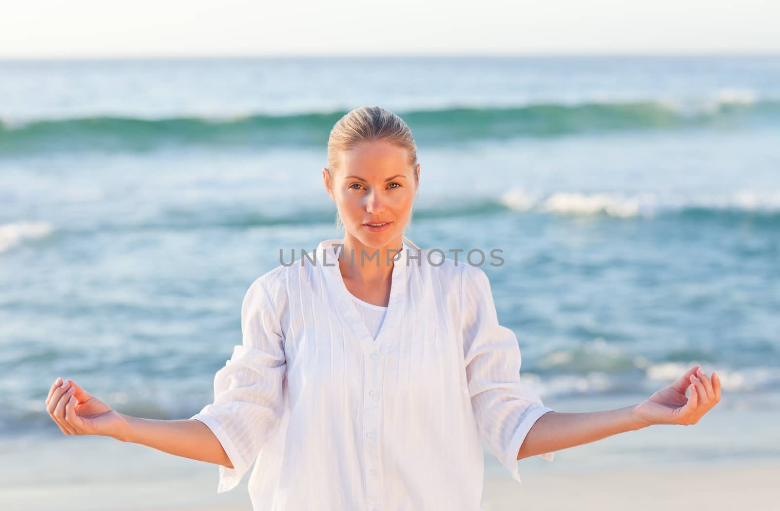 Active woman practicing yoga on the beach by Wavebreakmedia