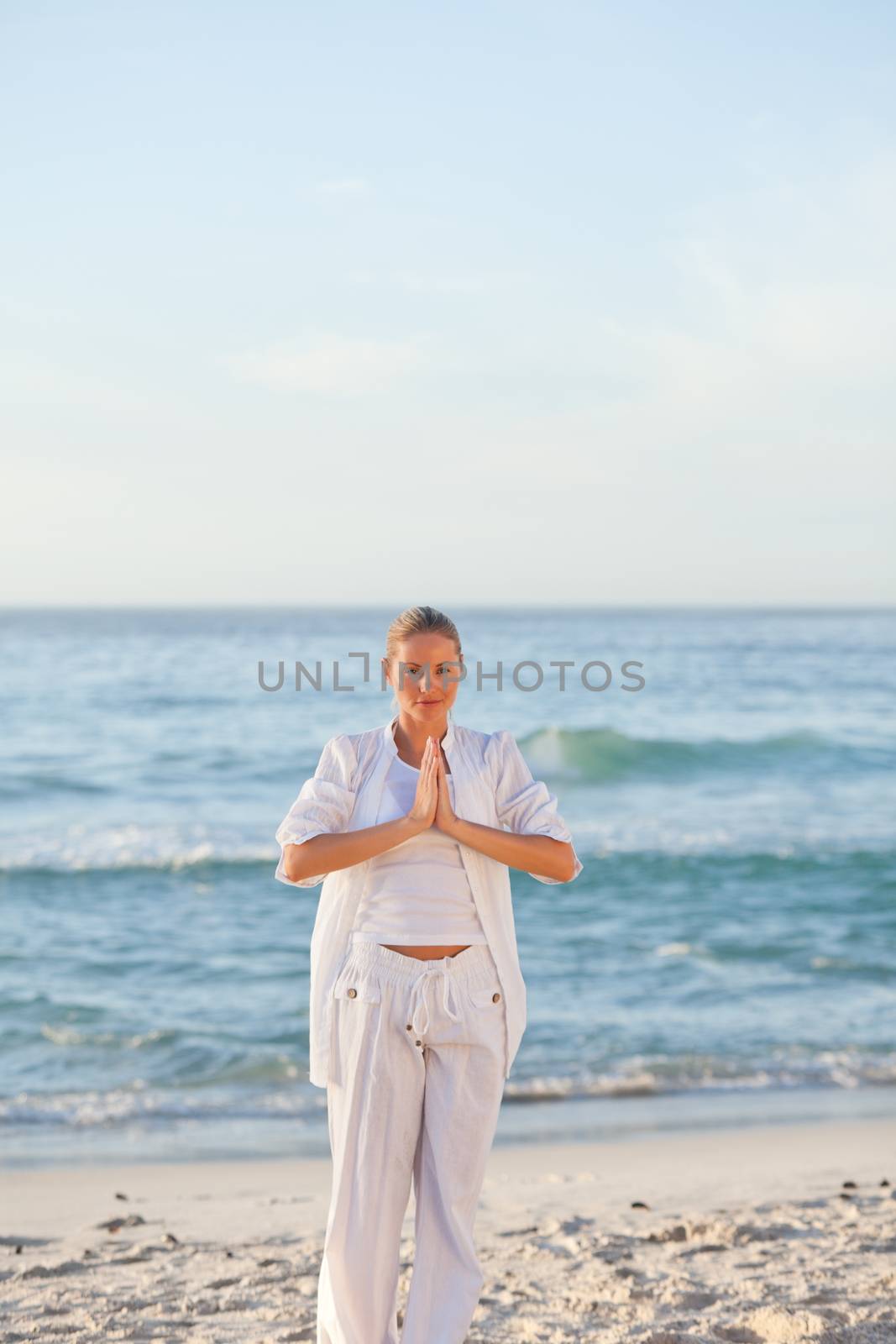 Woman practicing yoga against the sea by Wavebreakmedia
