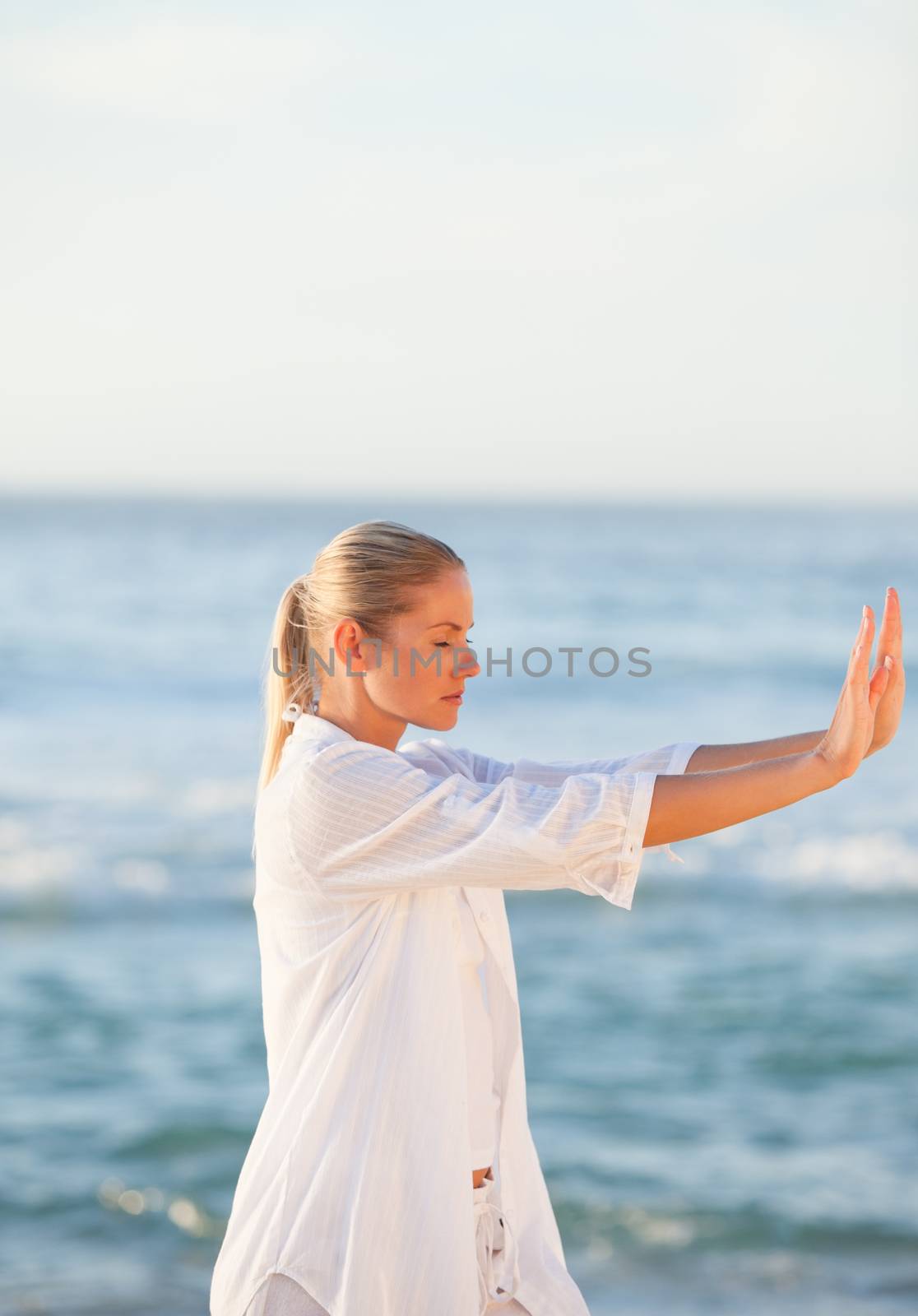 Woman practicing yoga against the sea