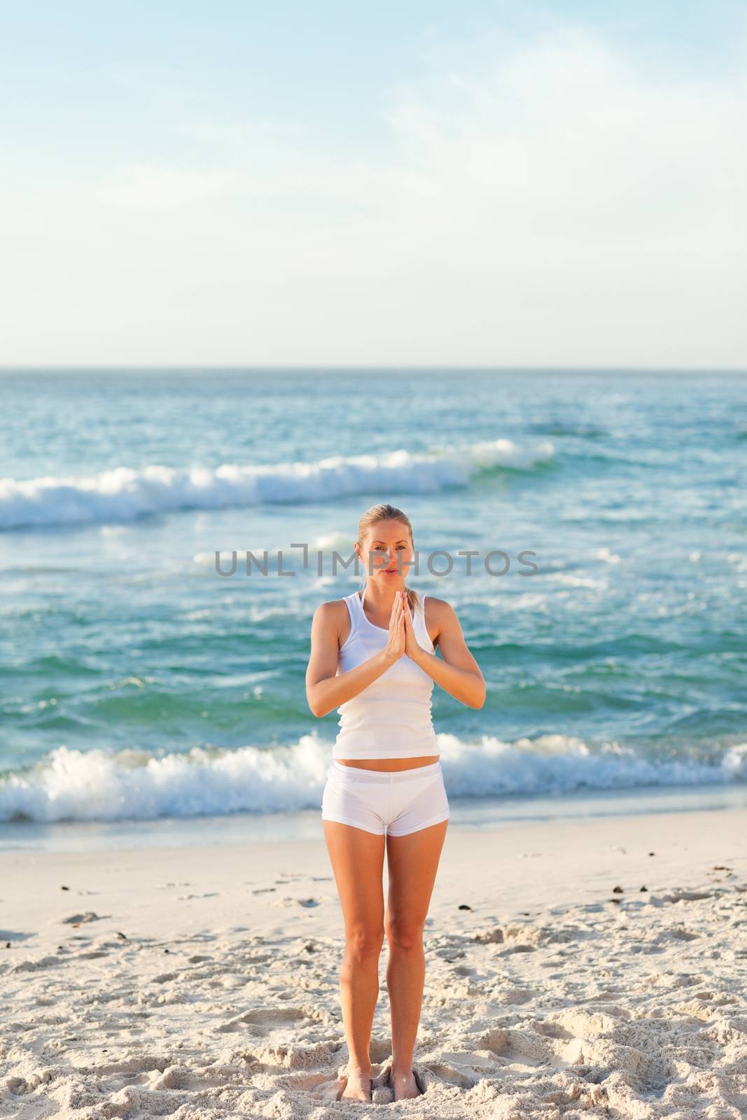 Woman practicing yoga against the sea by Wavebreakmedia