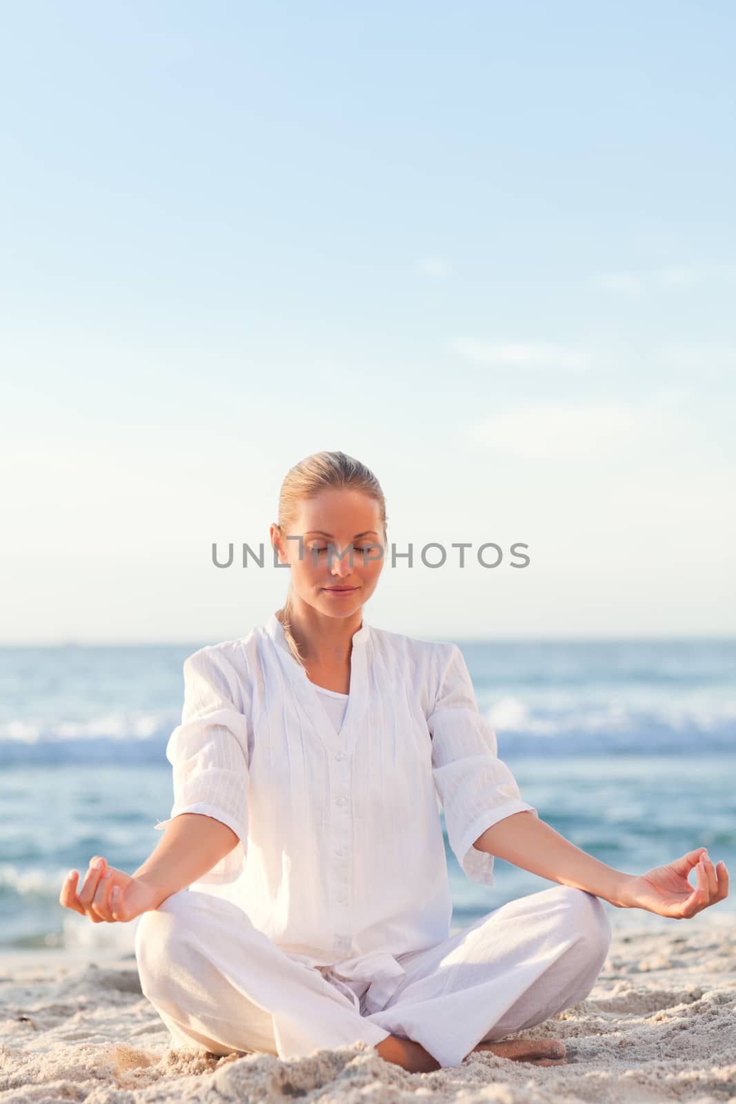 Peaceful woman practicing yoga against the sea