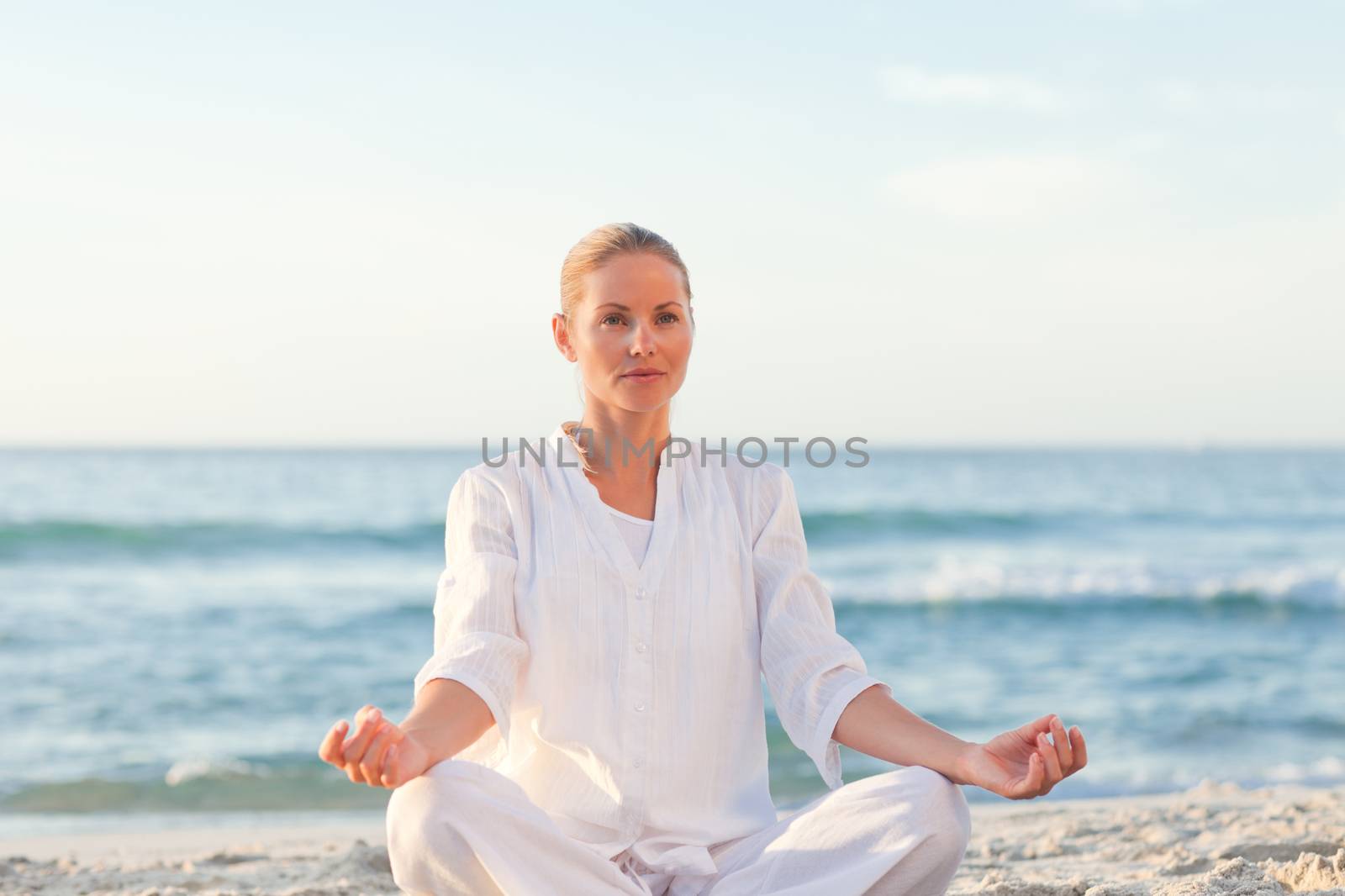 Peaceful woman practicing yoga against the sea