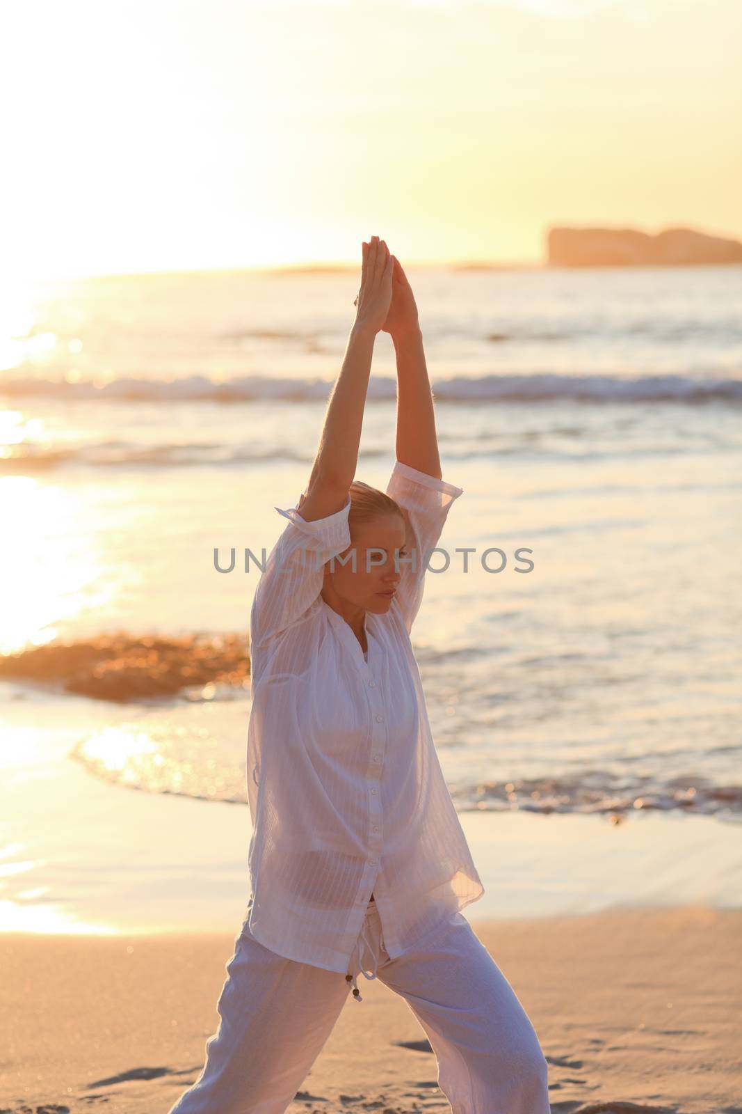 Woman practicing yoga during the sunset 