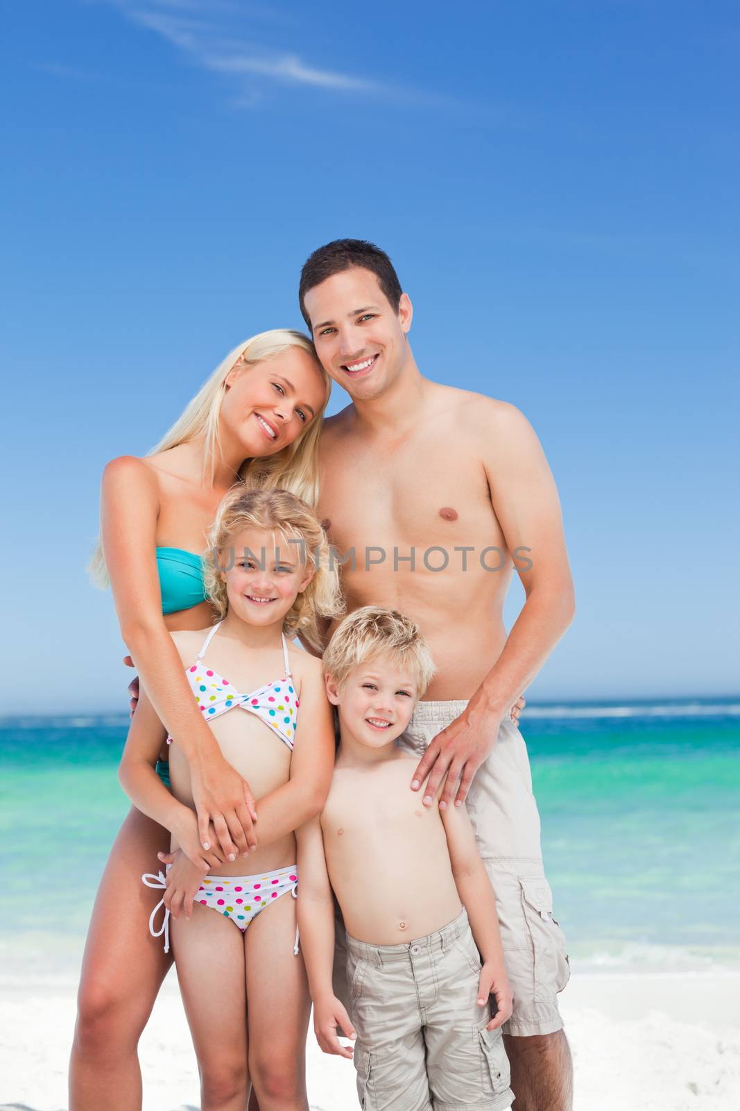 Happy family on the beach against the sea