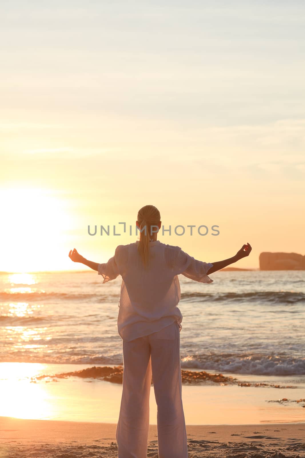 Woman practicing yoga during the sunset by Wavebreakmedia