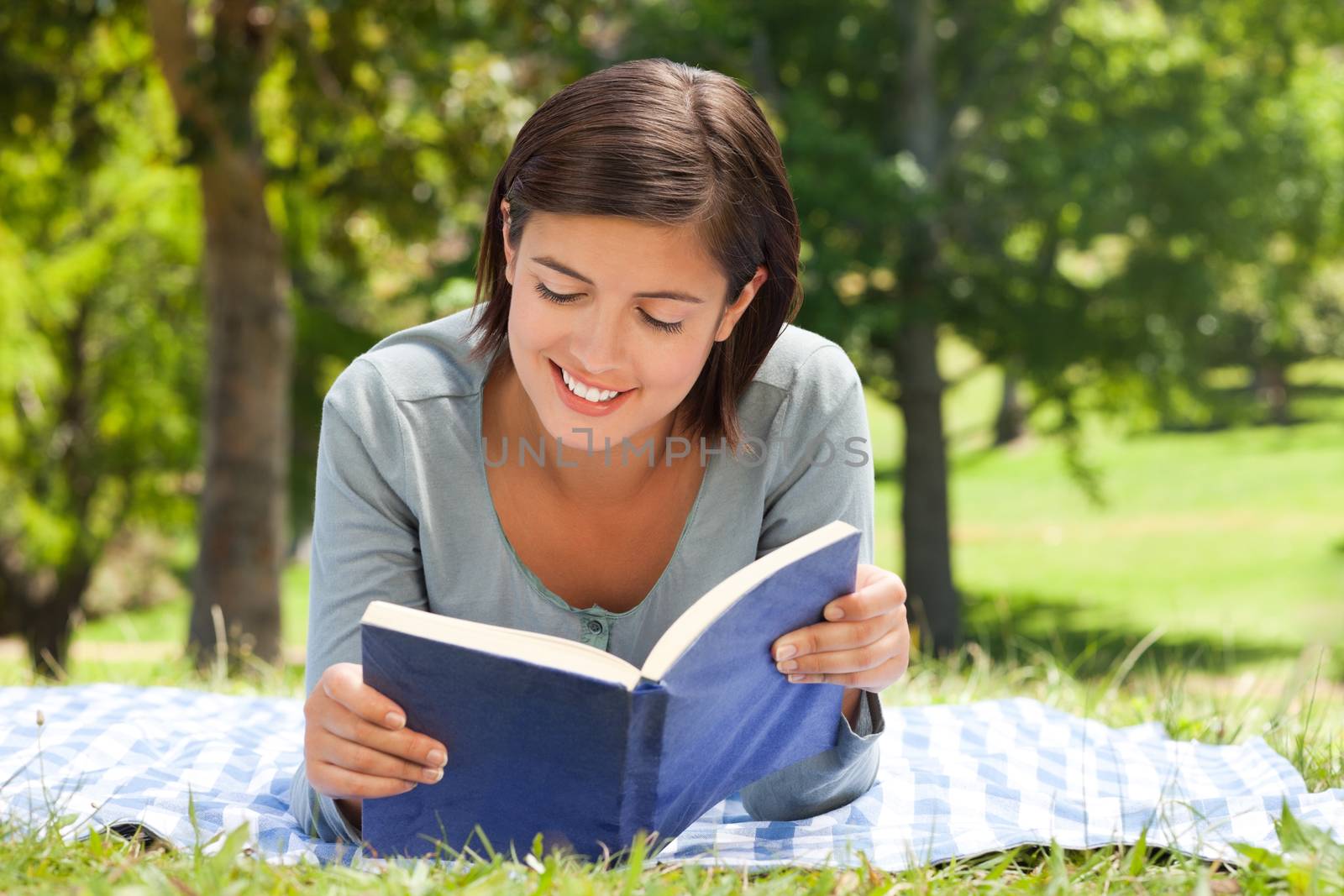 Woman reading a book in the park during the summer