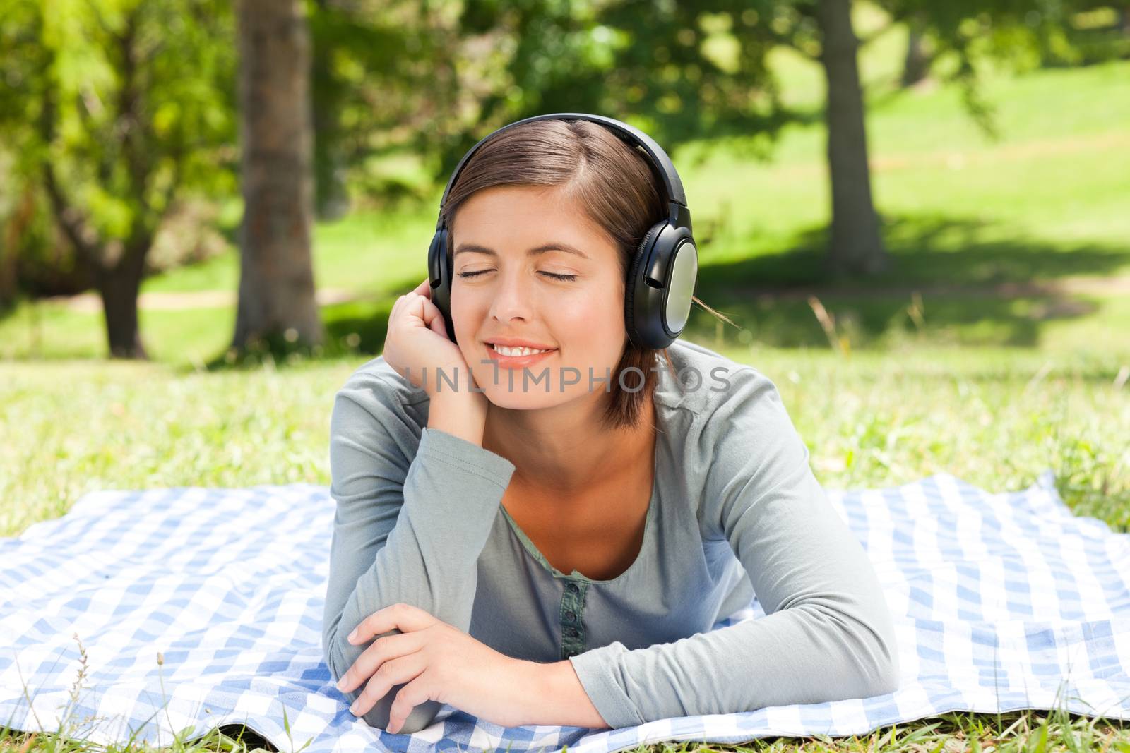 Woman listening to music in the park during the summer