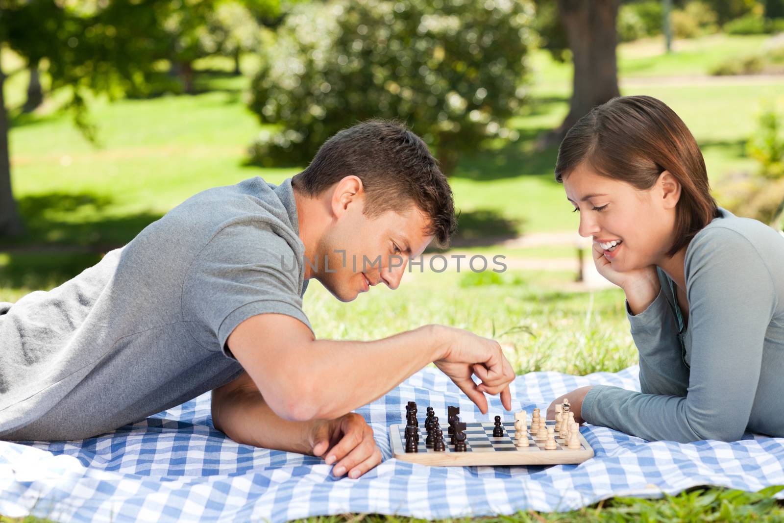 Couple playing chess in the park by Wavebreakmedia