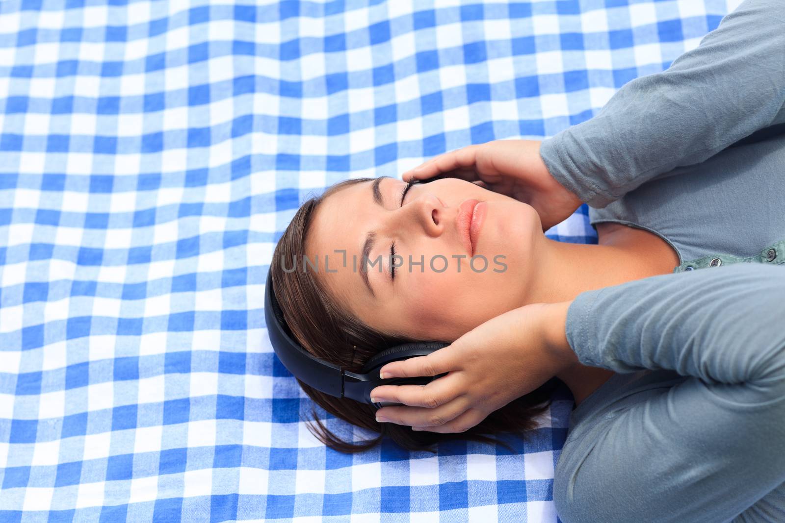 Woman listening to some music in the park during the summer