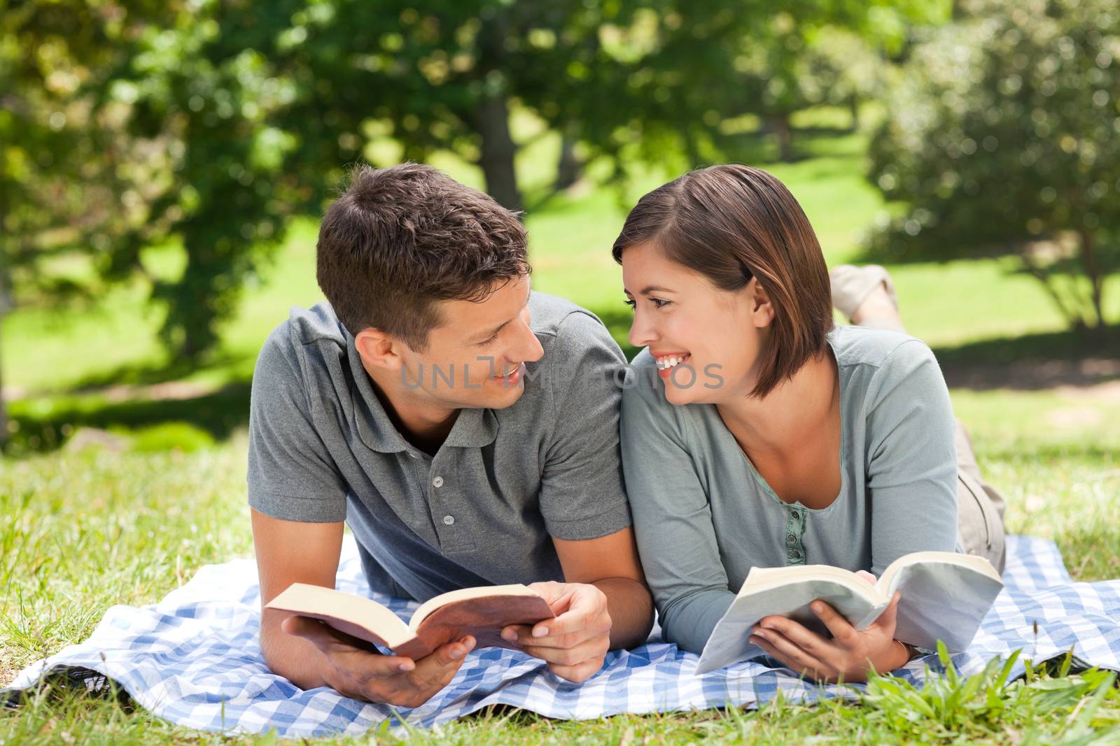 Couple reading a book in a park