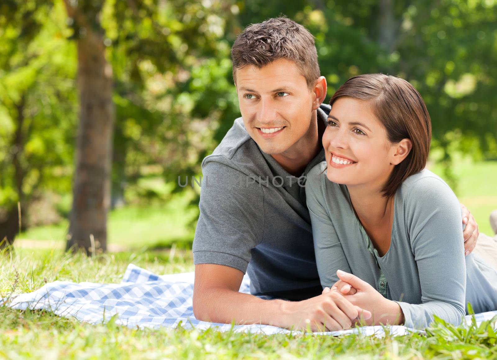 Couple lying down in the park during the summer