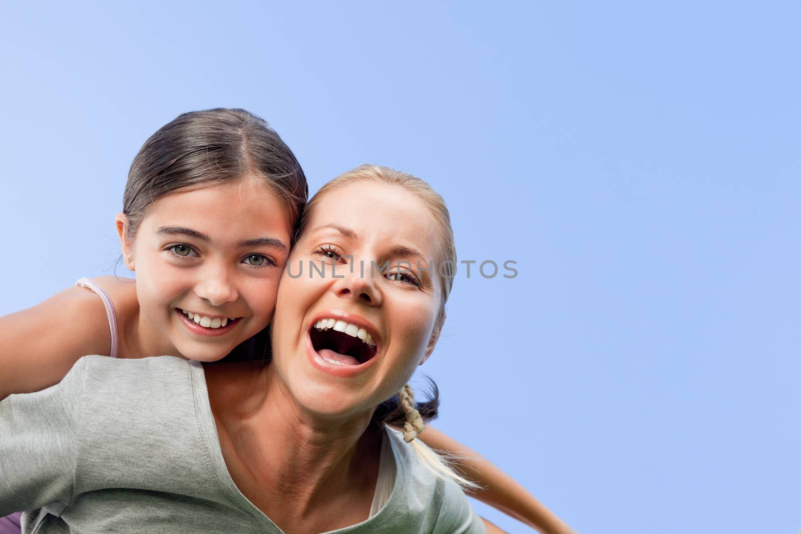 Mother and her daughter laughting in the park during the summer