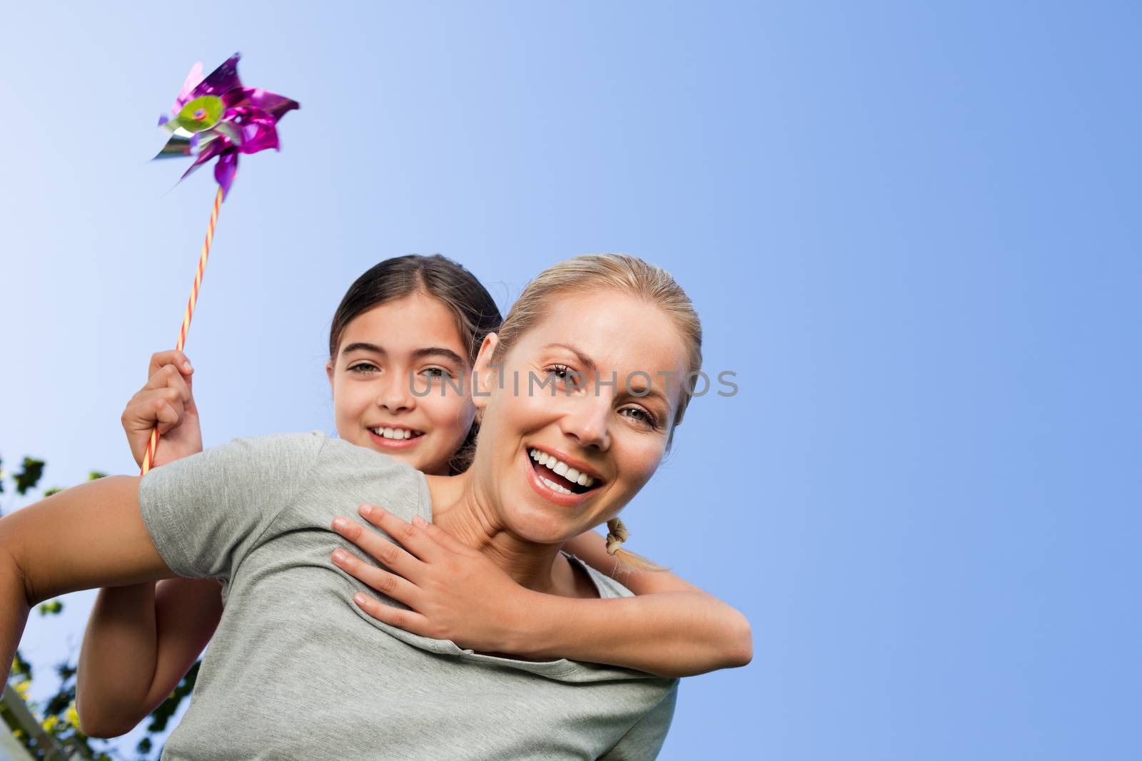 Mother and her daughter with a windmill during the summer