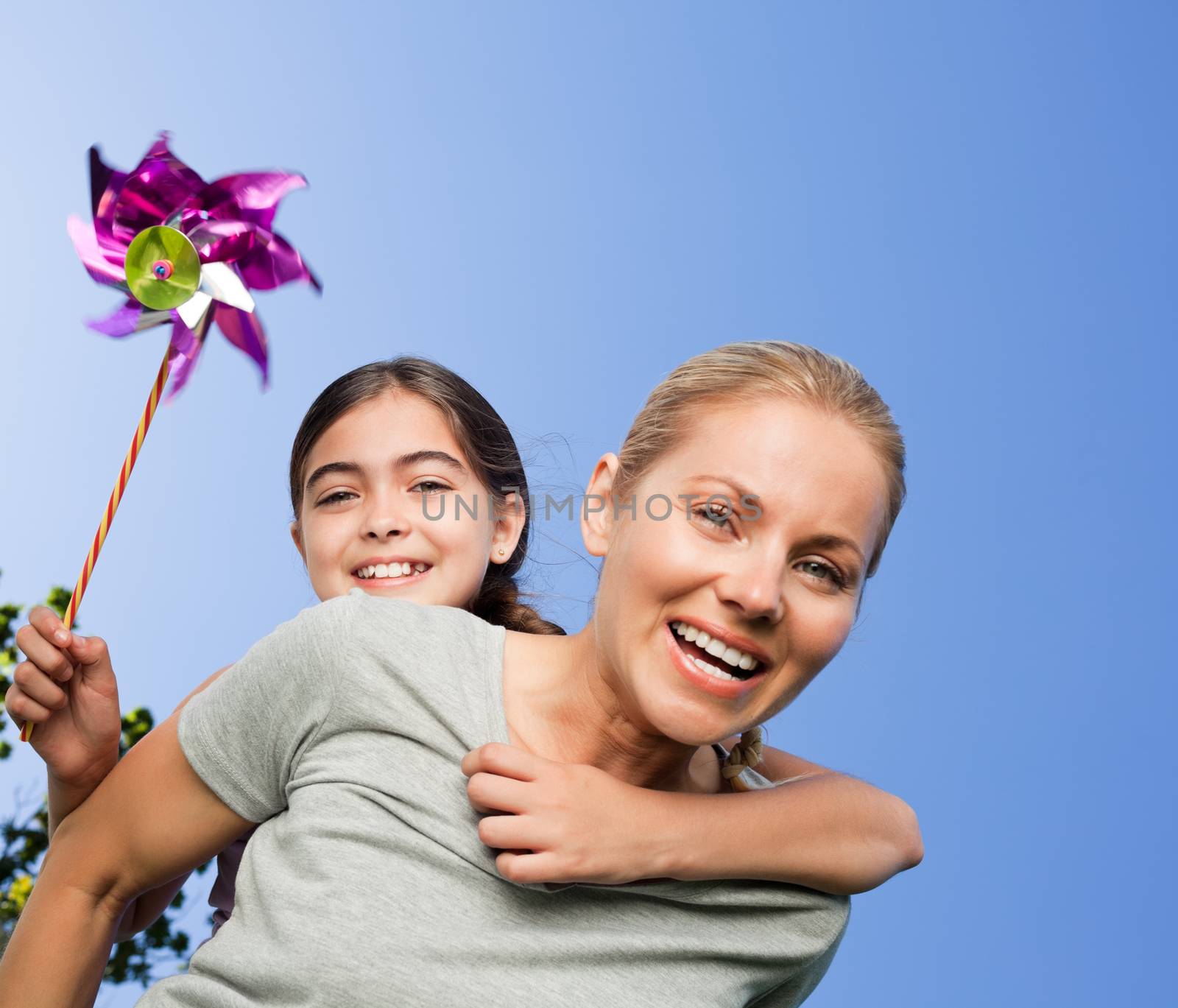 Mother and her daughter with a windmill by Wavebreakmedia