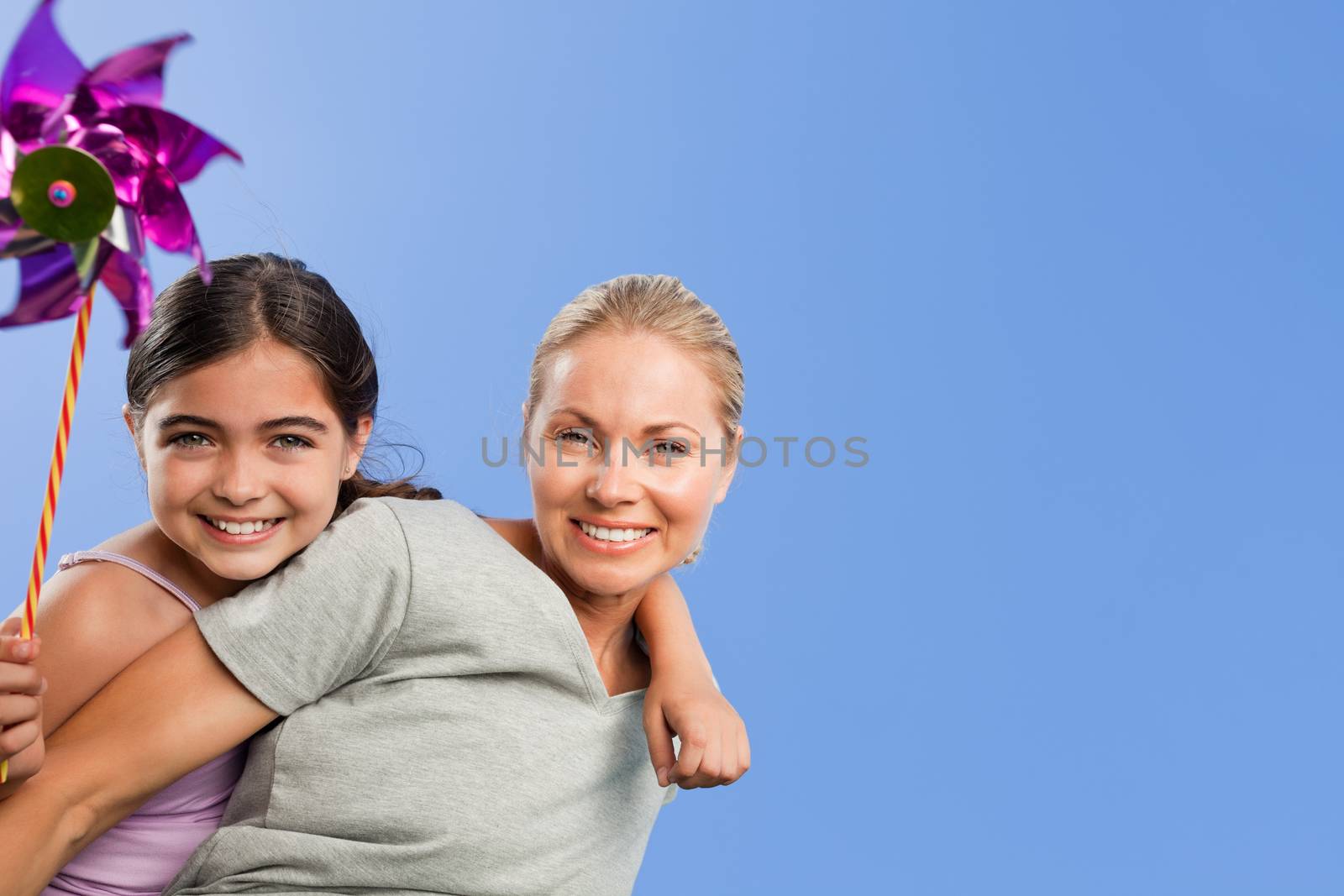 Mother and her daughter with a windmill by Wavebreakmedia
