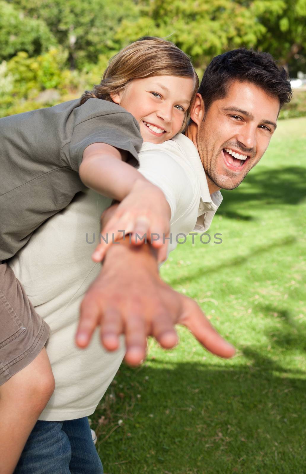 Father playing with his son in the park during the summer