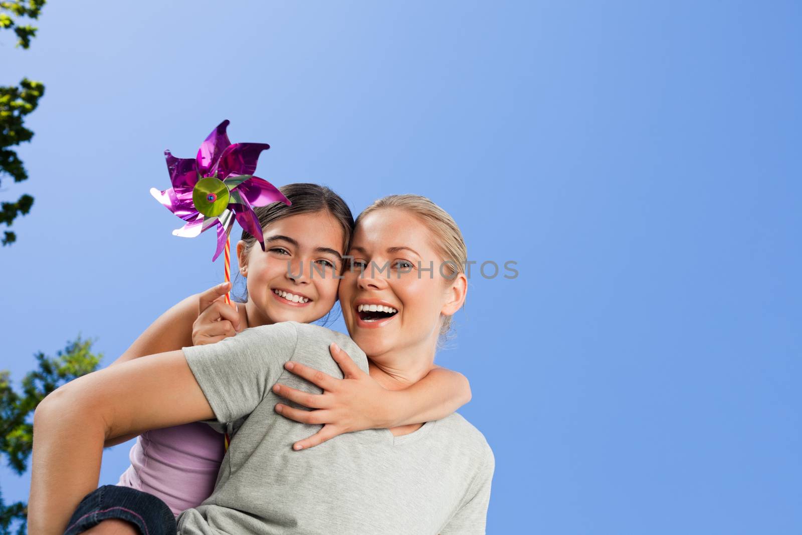 Mother and her daughter with a windmill during the summer