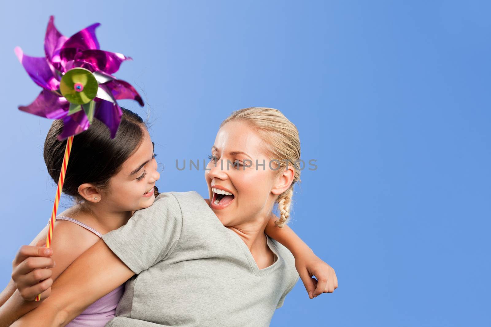 Mother and her daughter with a windmill during the summer