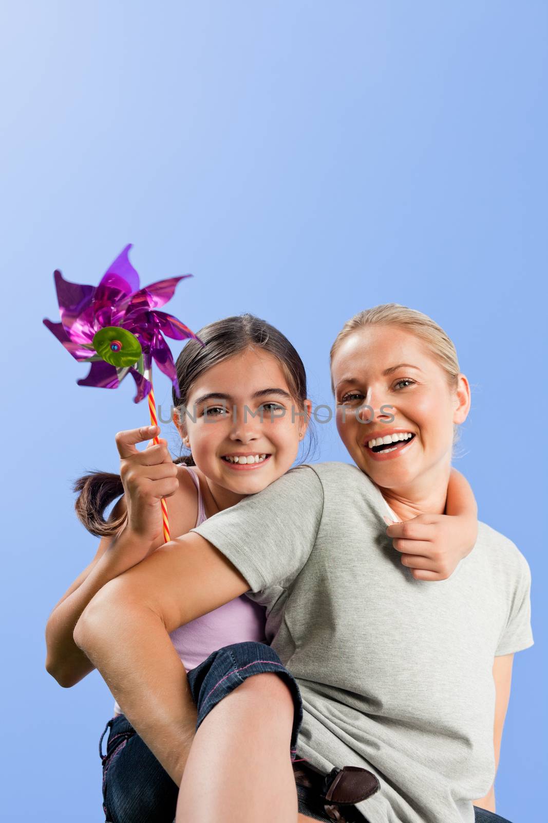 Mother and her daughter with a windmill during the summer