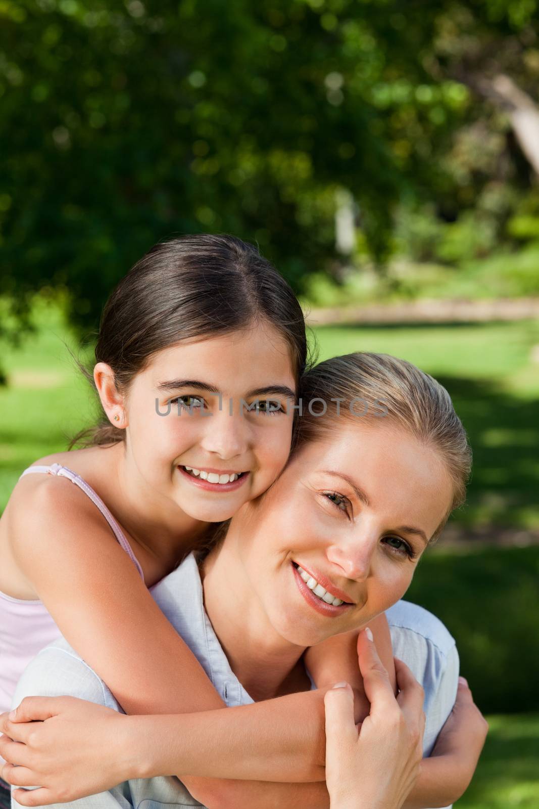 Cute daughter with her mother in the park during the summer