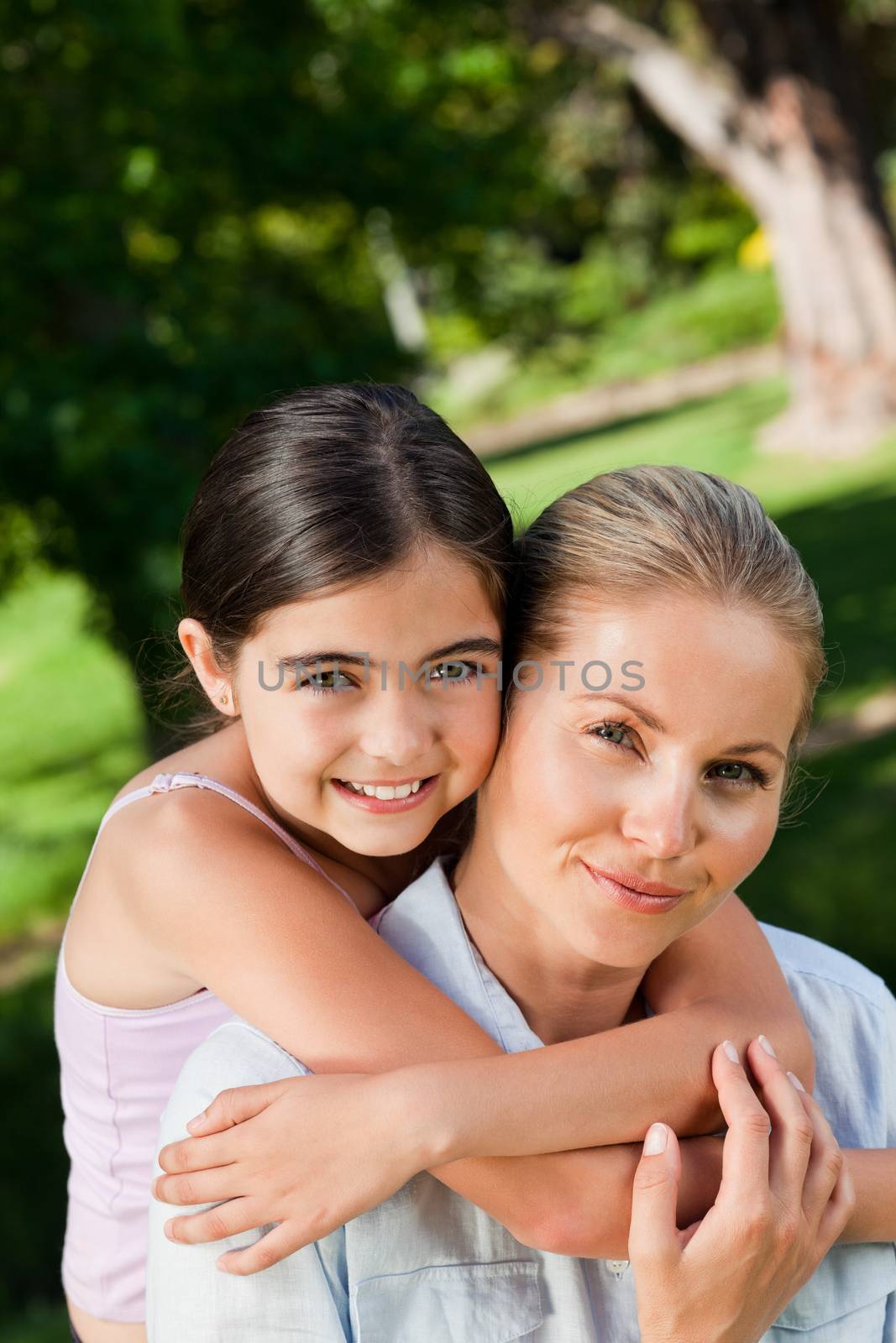 Cute daughter with her mother in the park during the summer