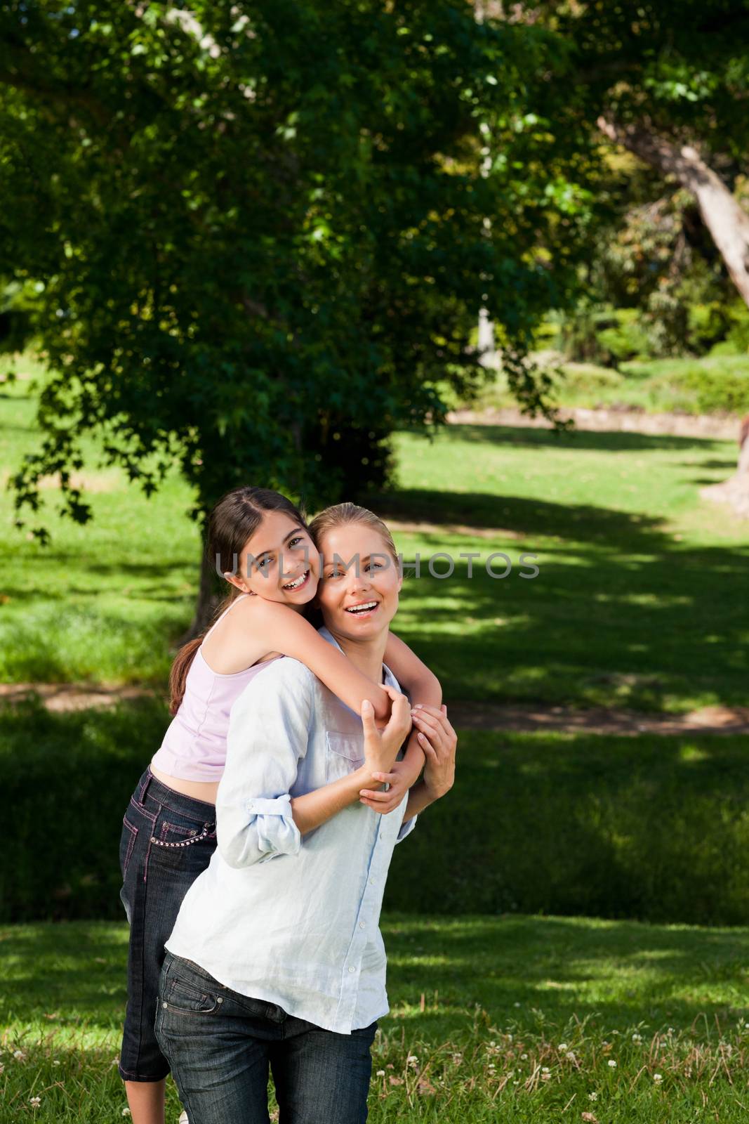 Mother giving daughter a piggyback during the summer