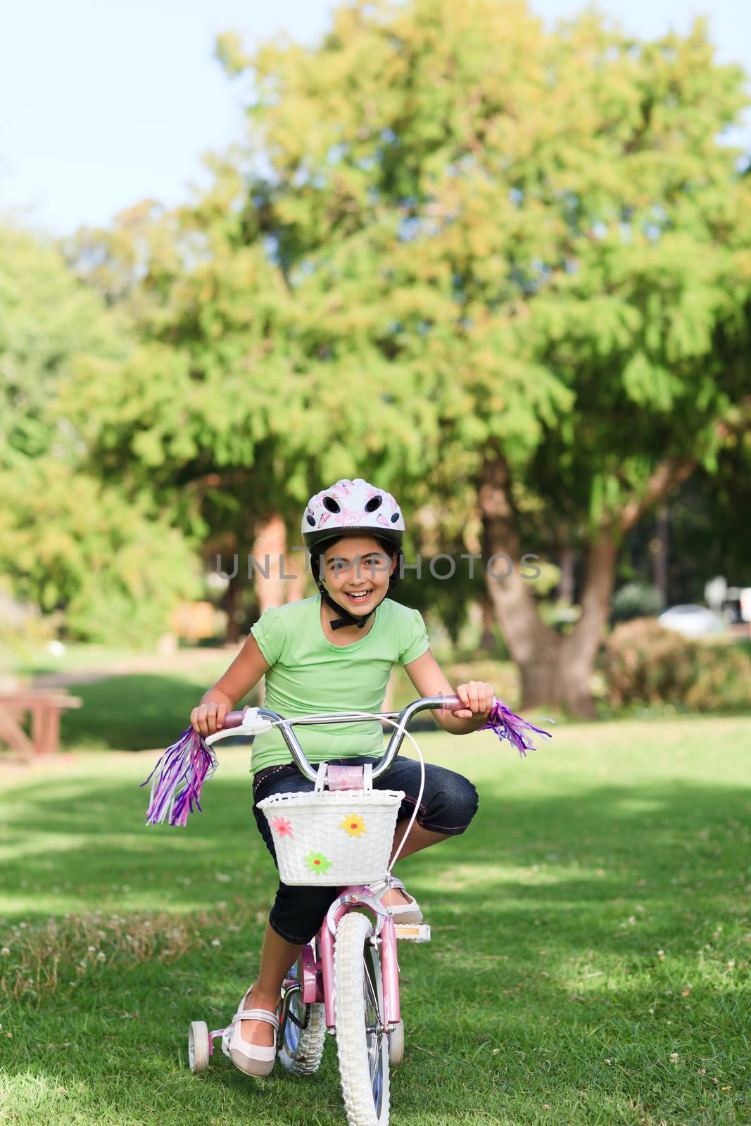 Little girl with her bike in a park during the summer