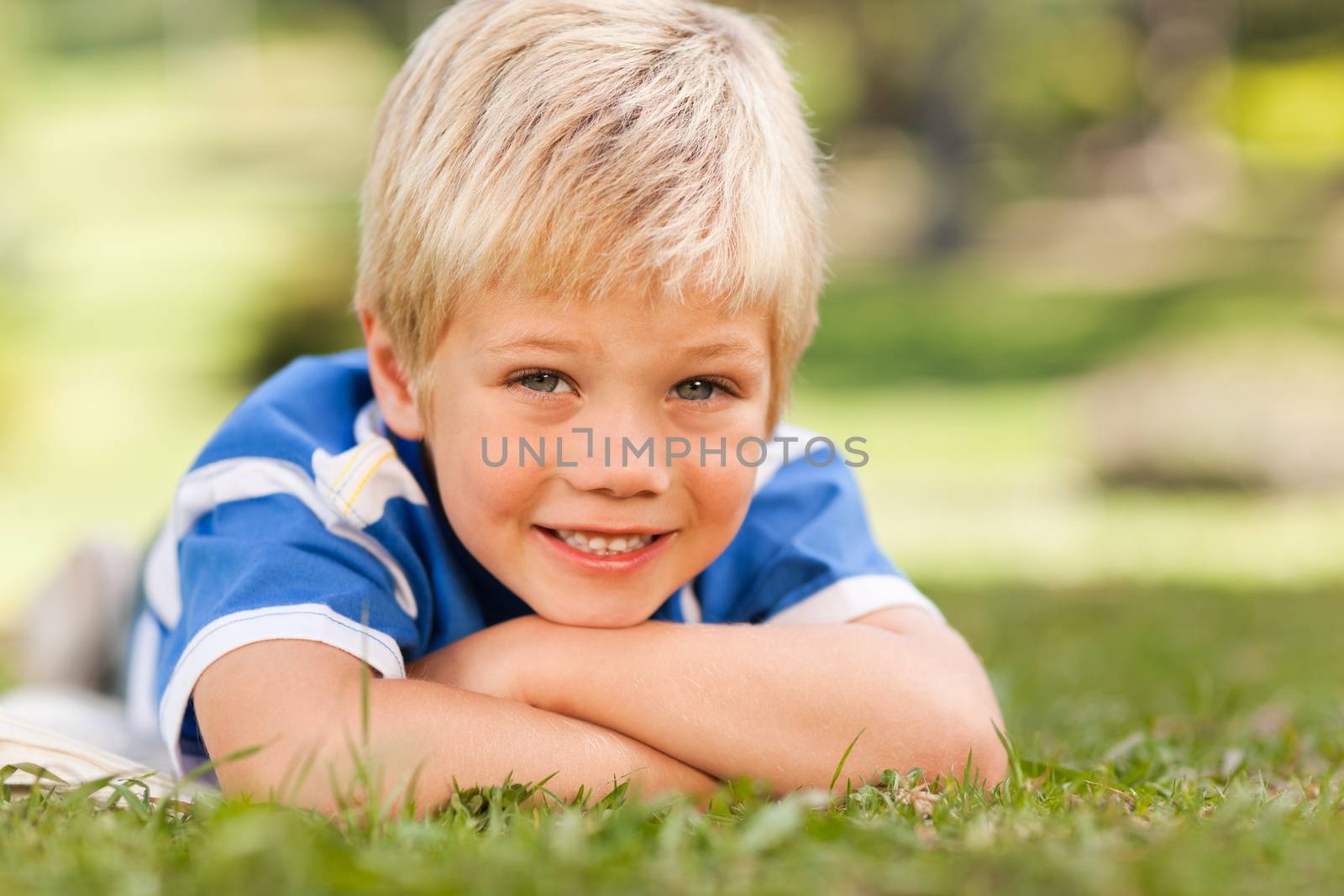 Boy lying down in the park by Wavebreakmedia