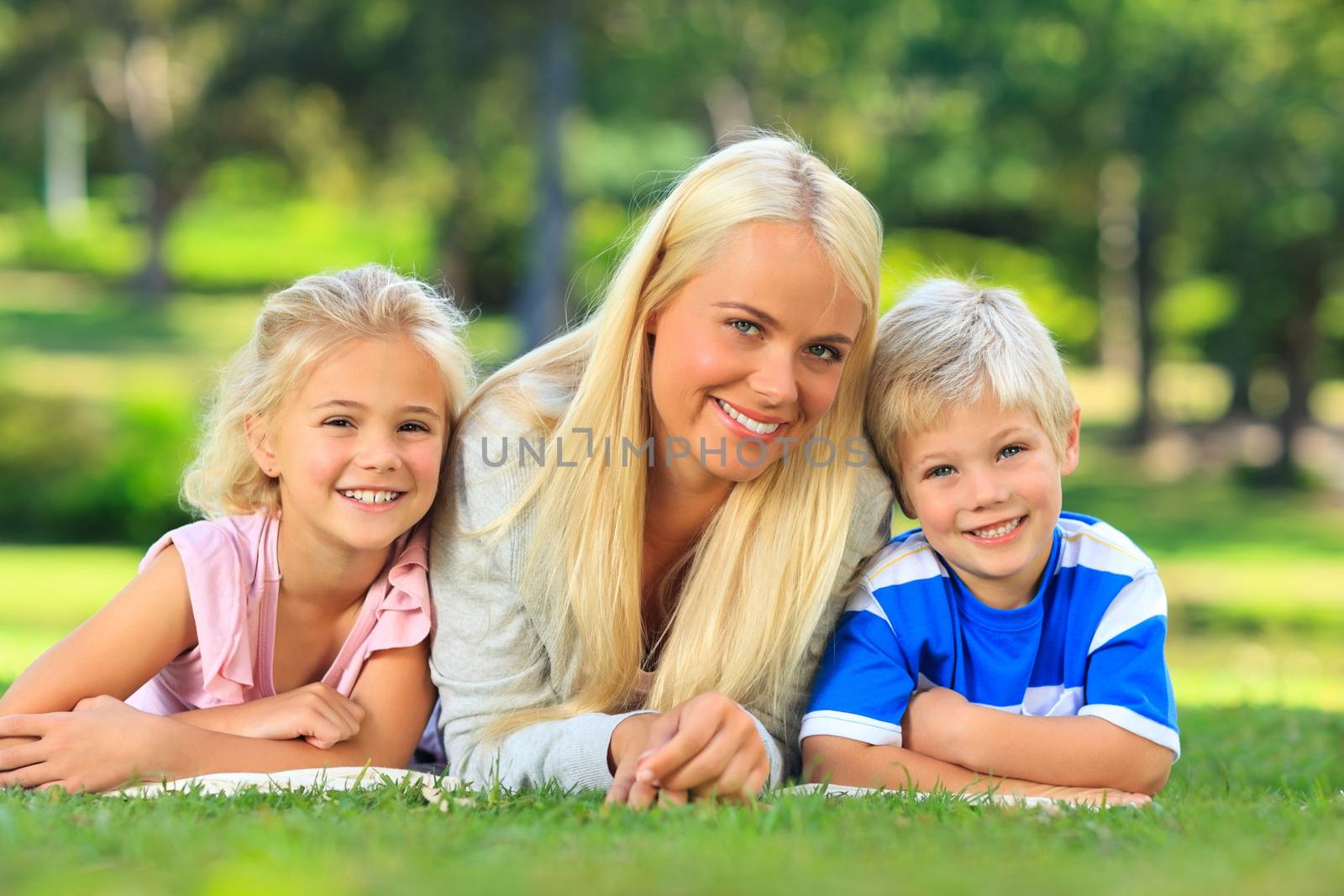 Mother with her children lying down in the park during the summer