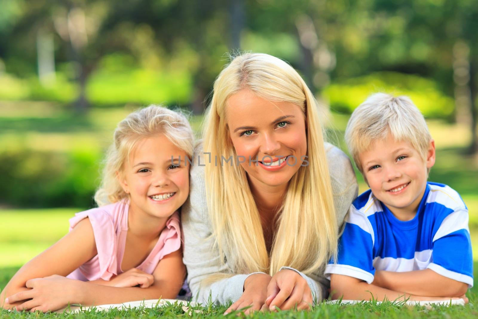 Mother with her children lying down during the summer by Wavebreakmedia