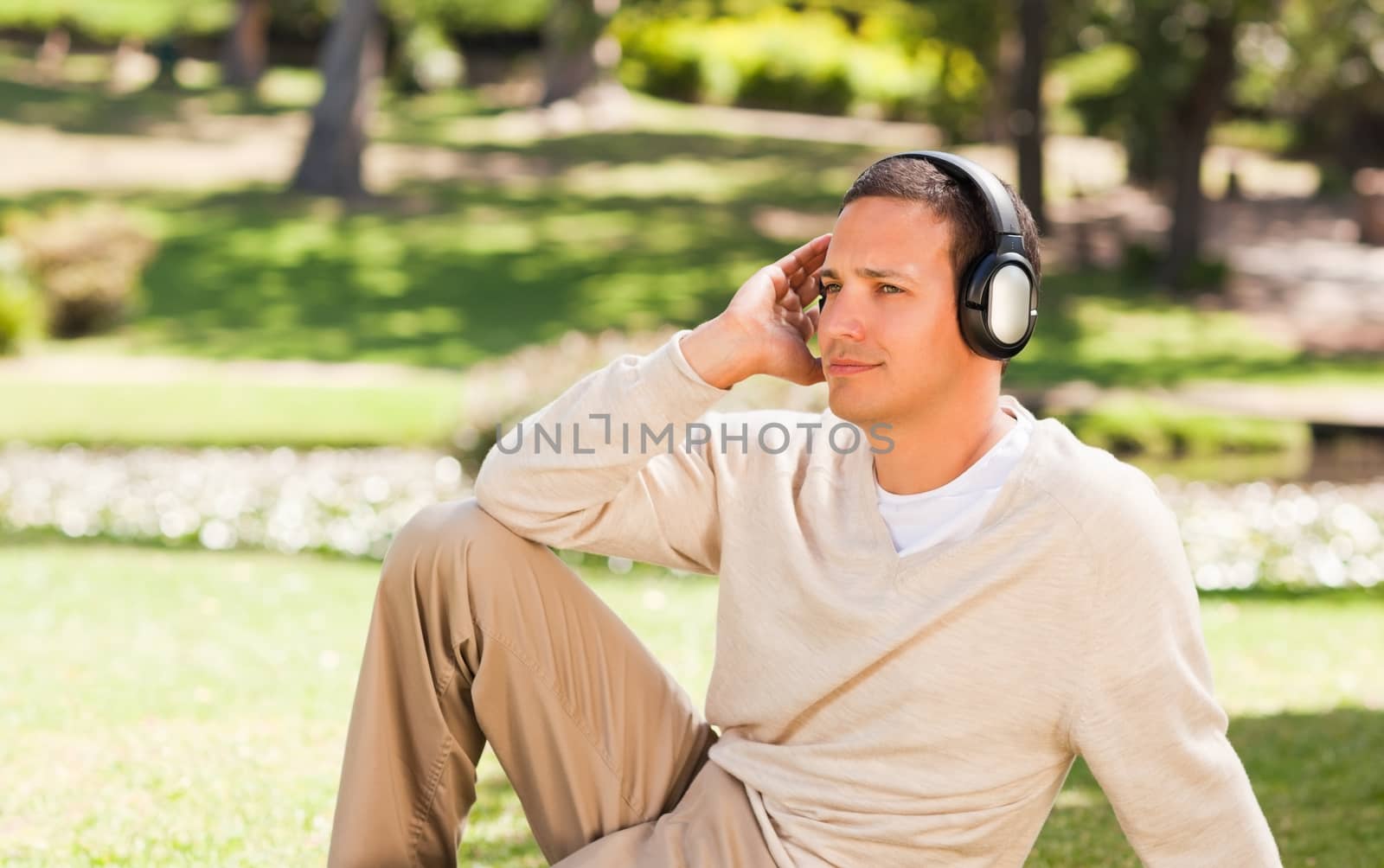 Man listening to music in the park by Wavebreakmedia