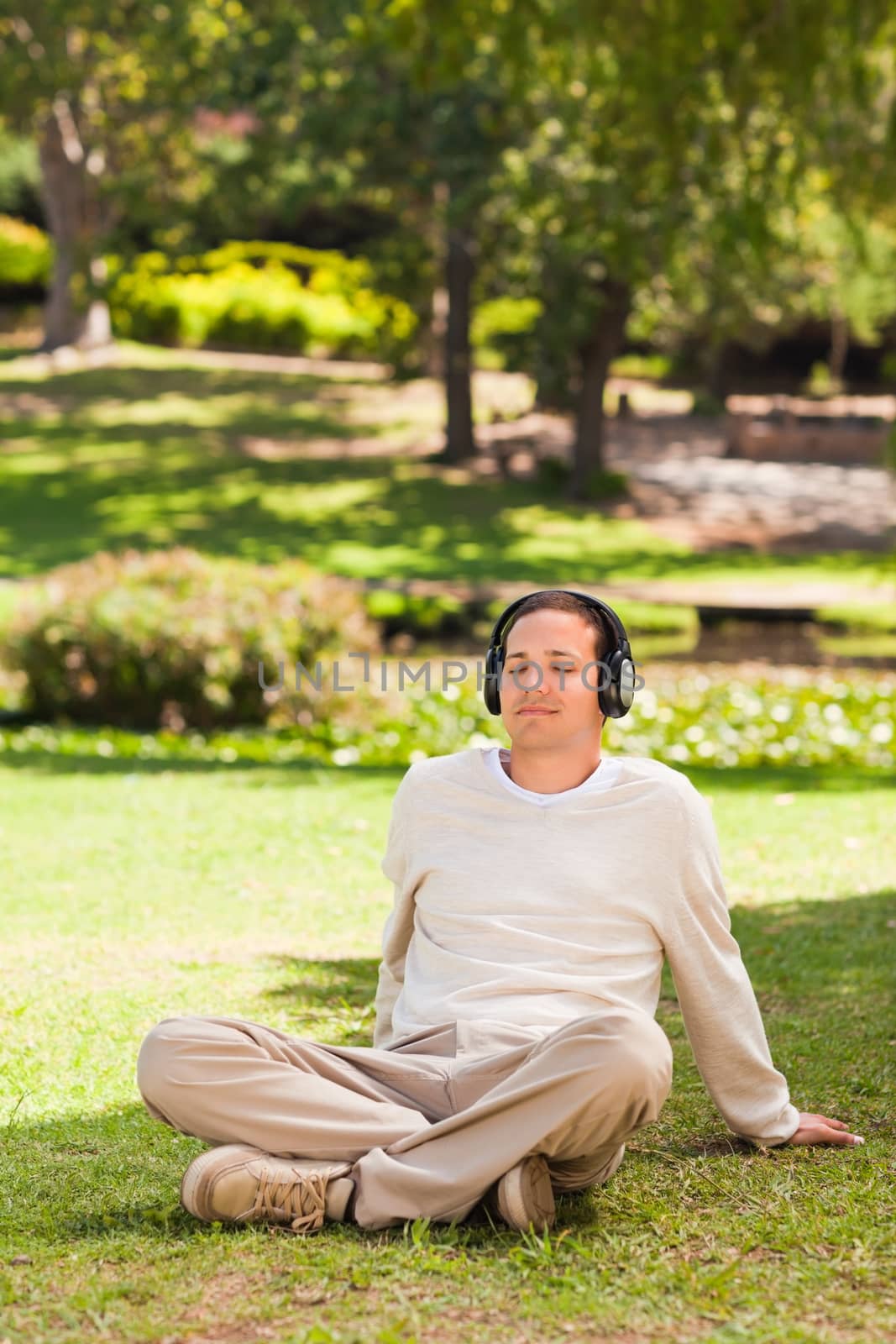 Man listening to music in the park during the summer 