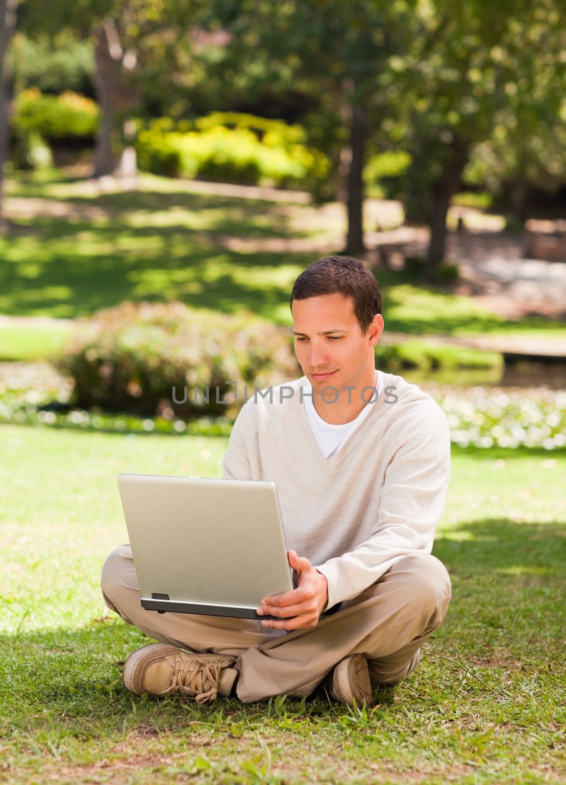 Man working on his laptop in the park by Wavebreakmedia