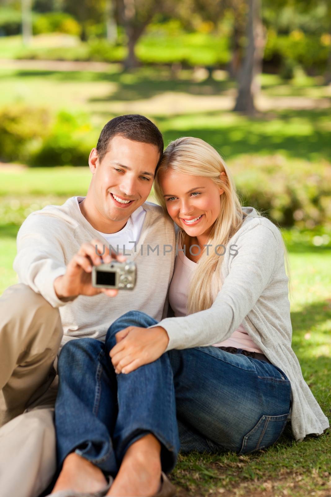 Young couple taking a photo of themselves in a park