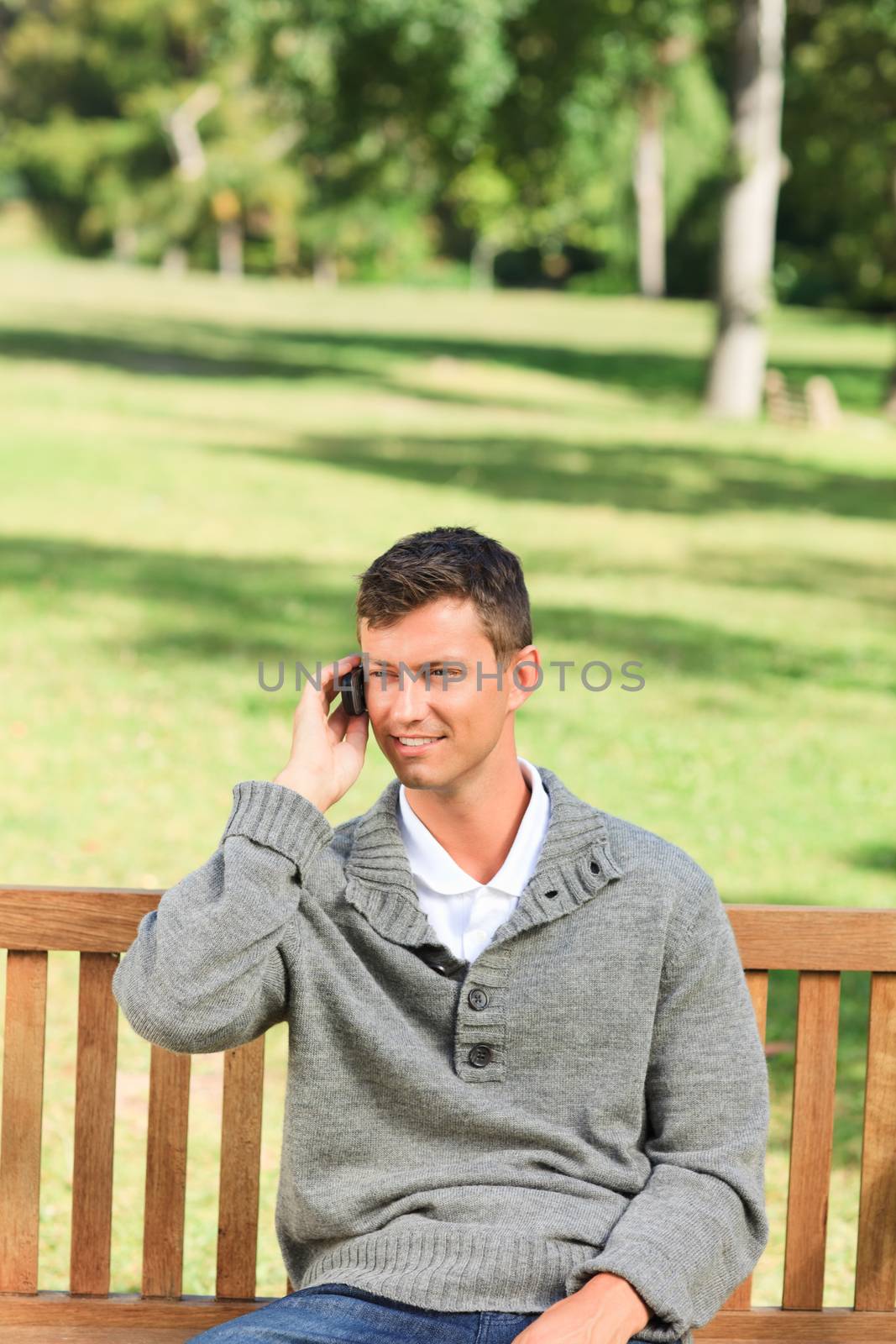 Man phoning on the bench by Wavebreakmedia