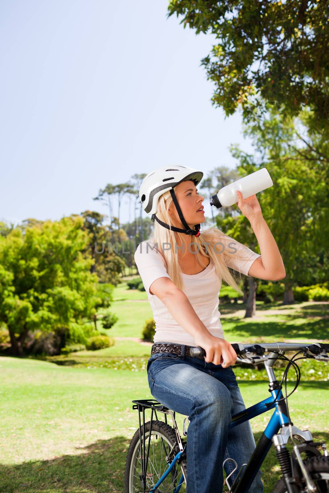 Woman in the park with her bike during the summer 