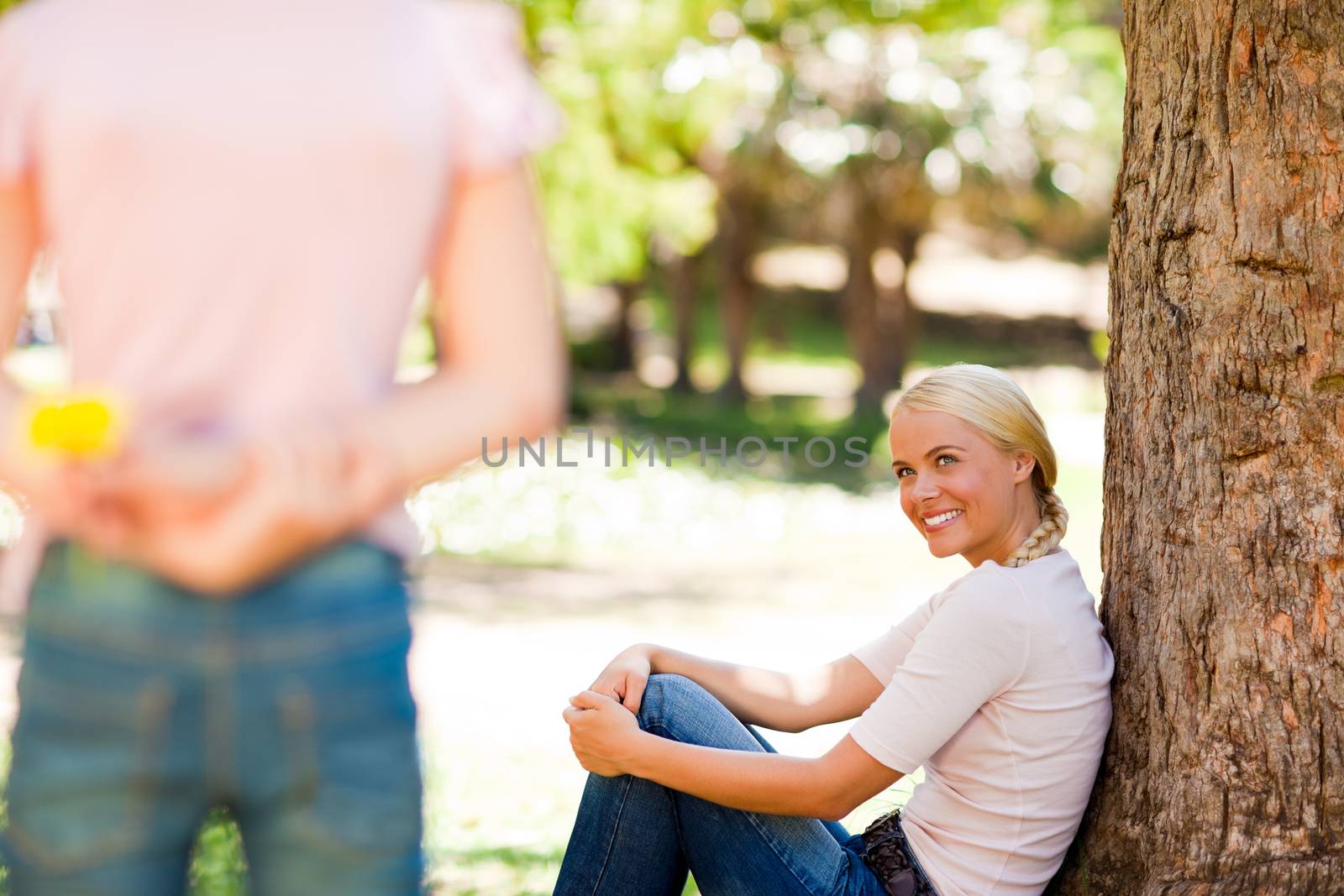 Daughter offering a flower to her mother during the summer in a park
