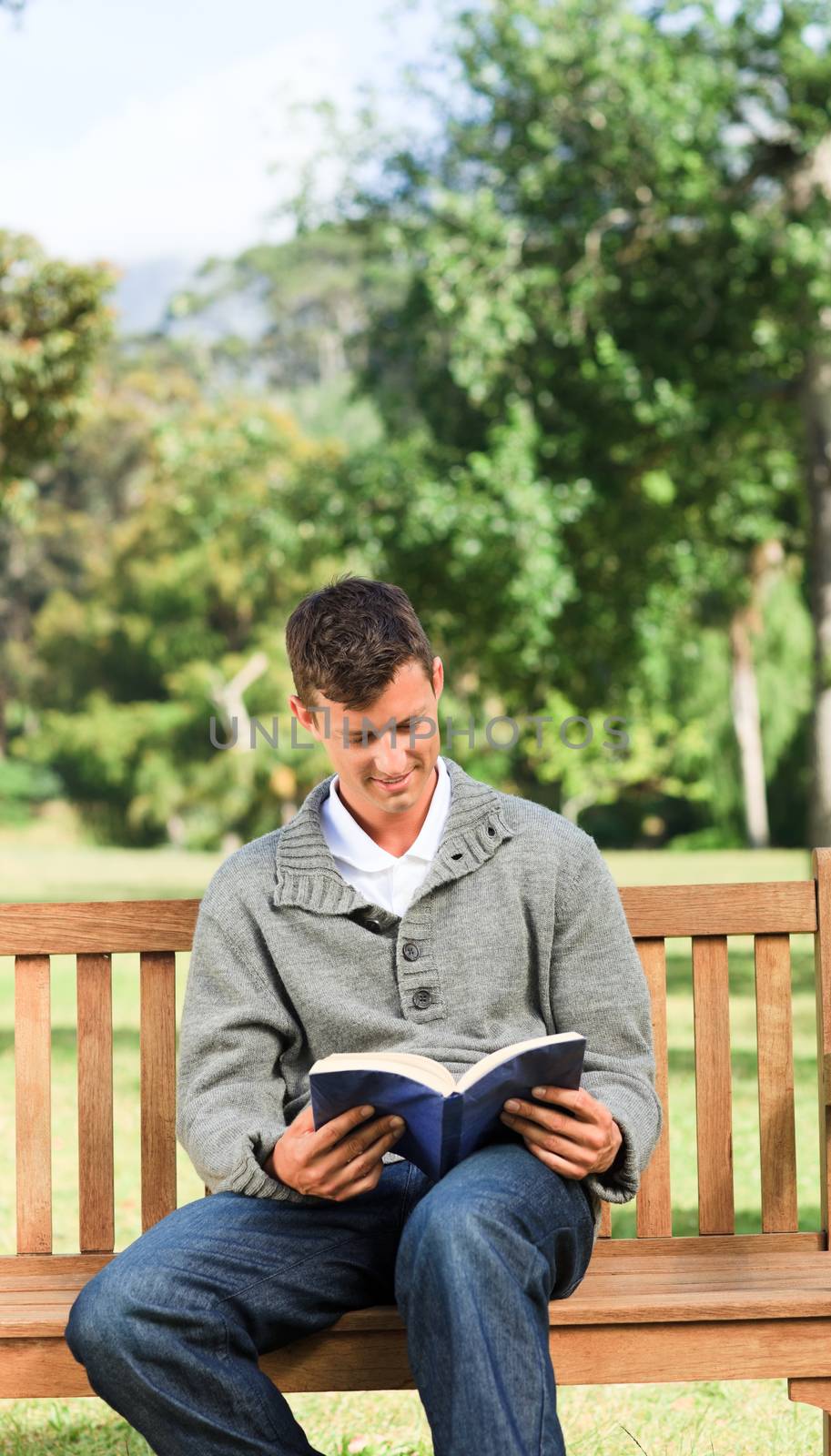 Man reading his book on the bench by Wavebreakmedia