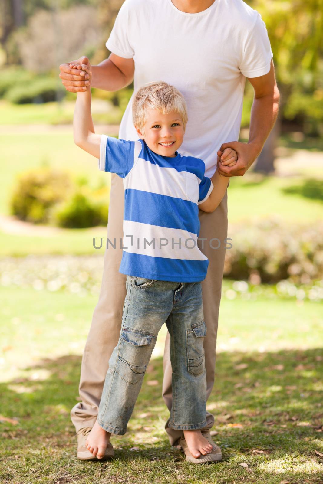 Father playing with his son in the park during the summer 