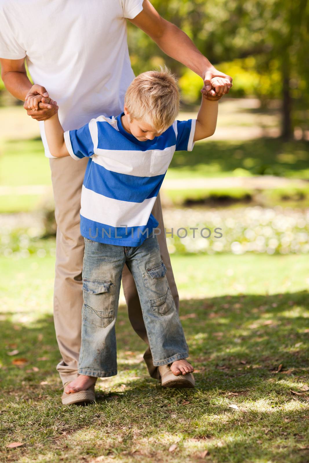 Father playing with his son during the summer in the park