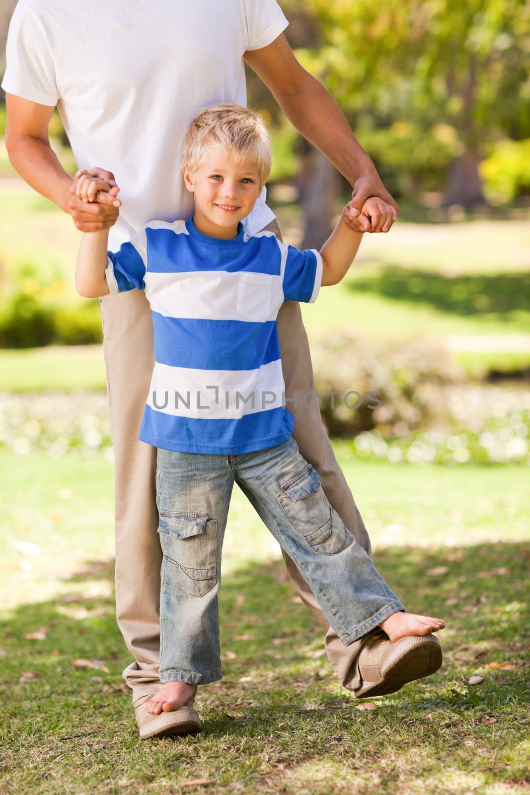 Son playing with his father in the park by Wavebreakmedia