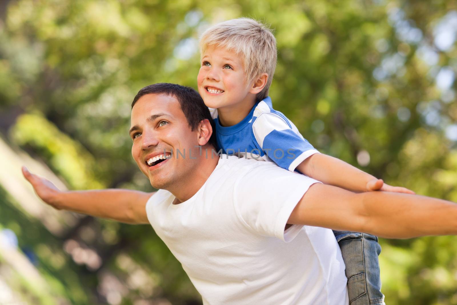 Son playing with his father in the park during the summer  by Wavebreakmedia