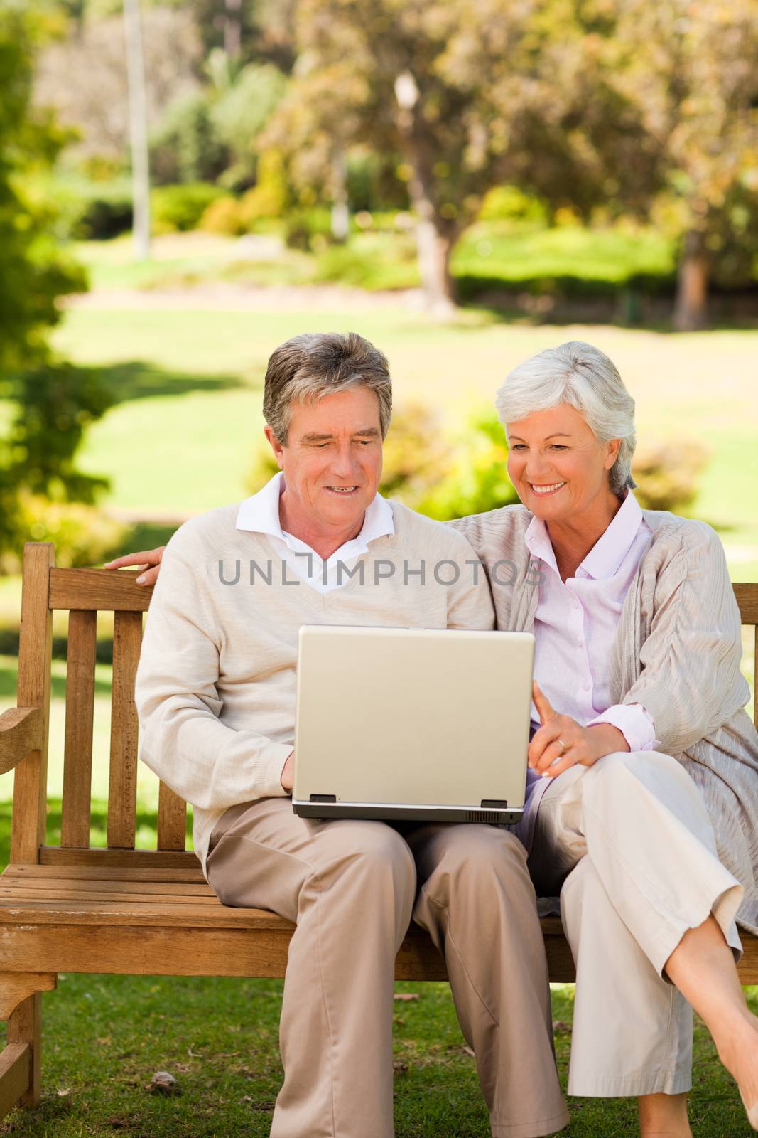 Couple working on their laptop sitting in the park