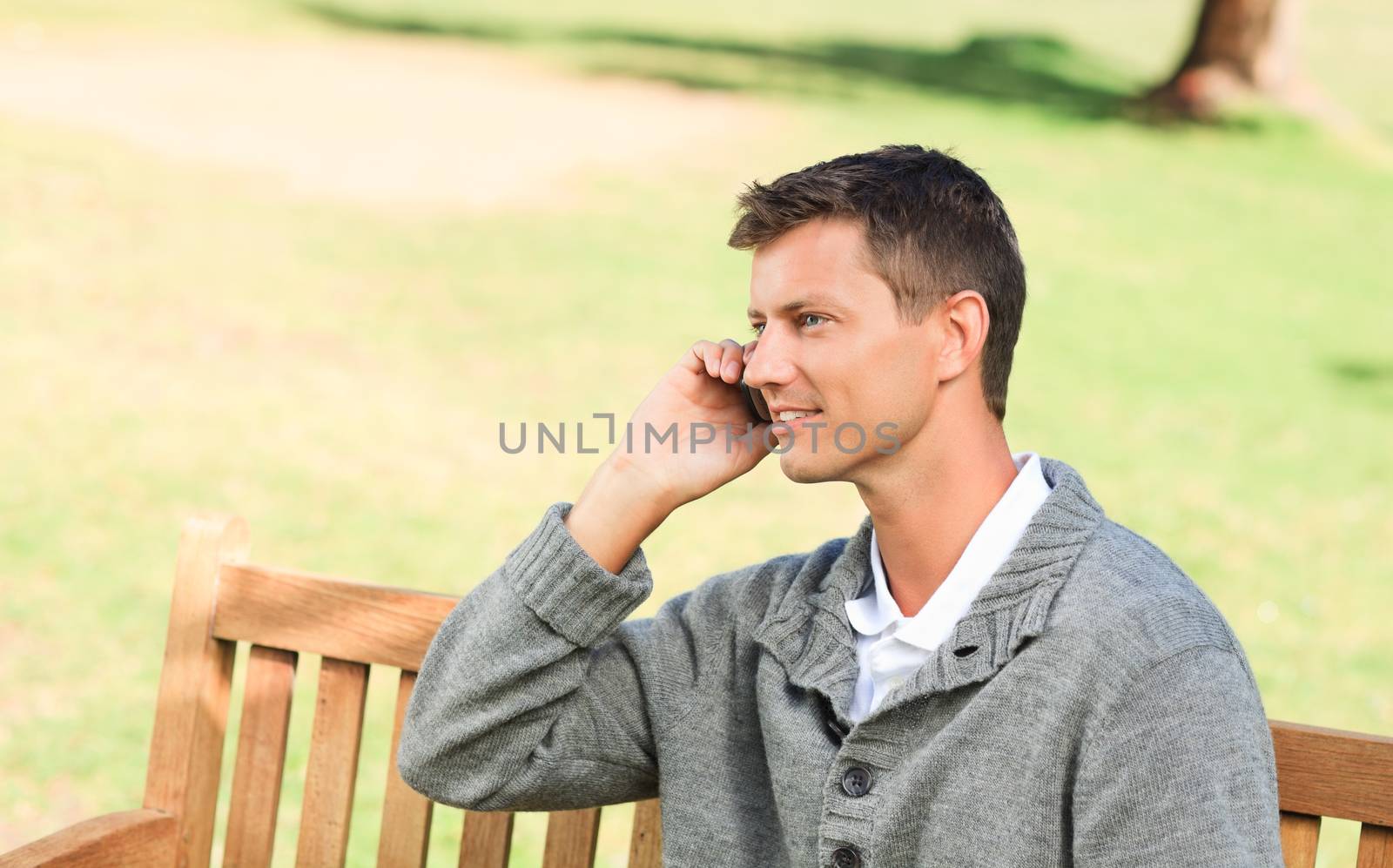 Man phoning on the bench by Wavebreakmedia