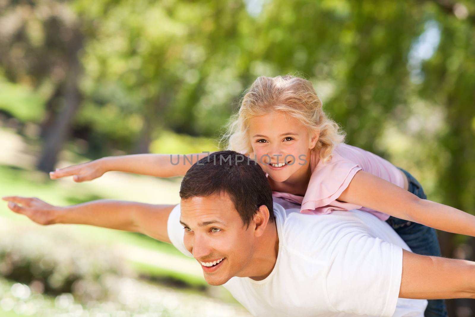 Little girl playing with her father during the summer  by Wavebreakmedia