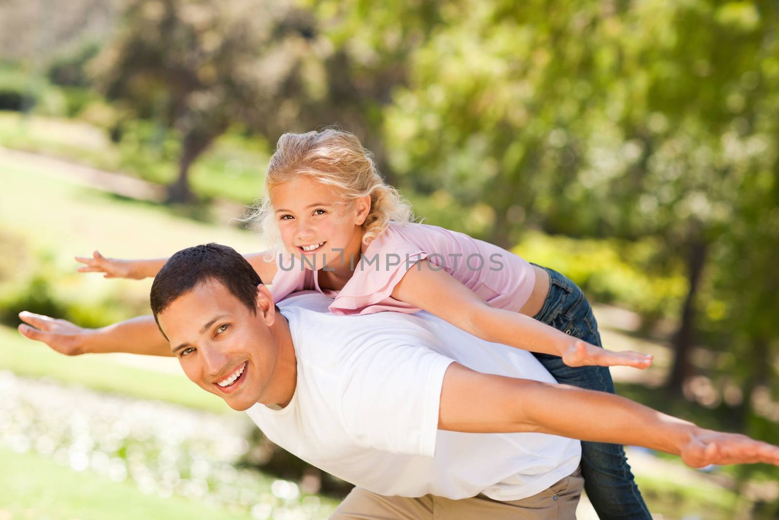 Little girl playing with her father during the summer 