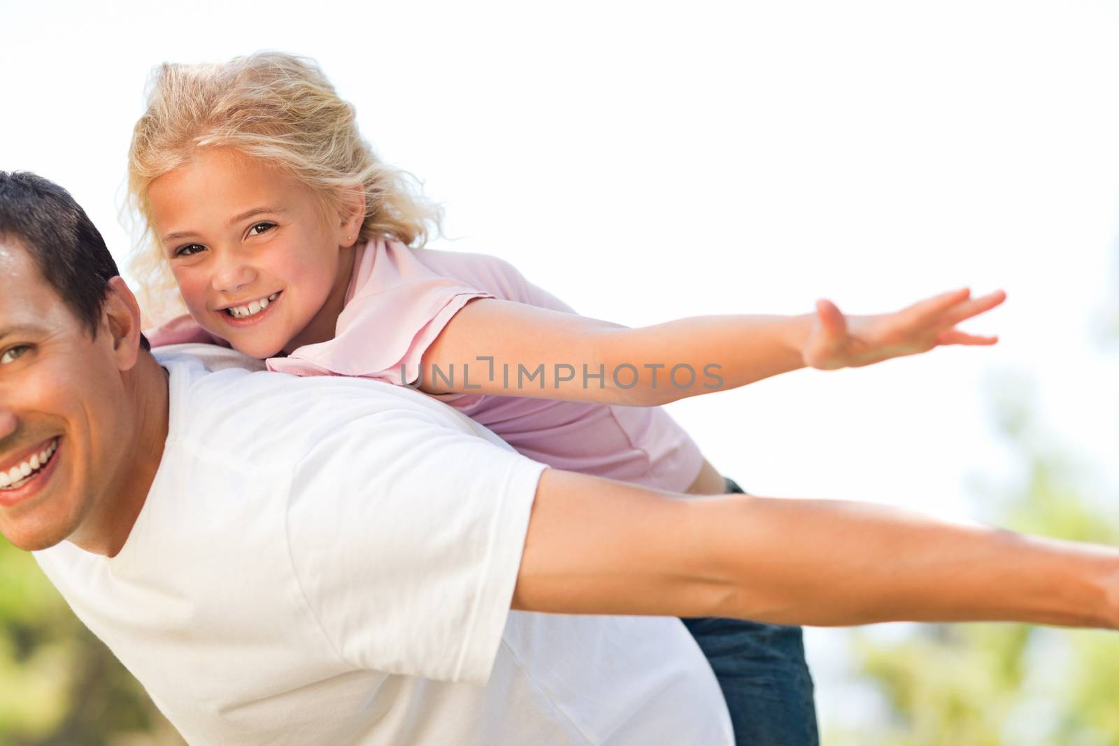 Little girl playing with her father in the park by Wavebreakmedia