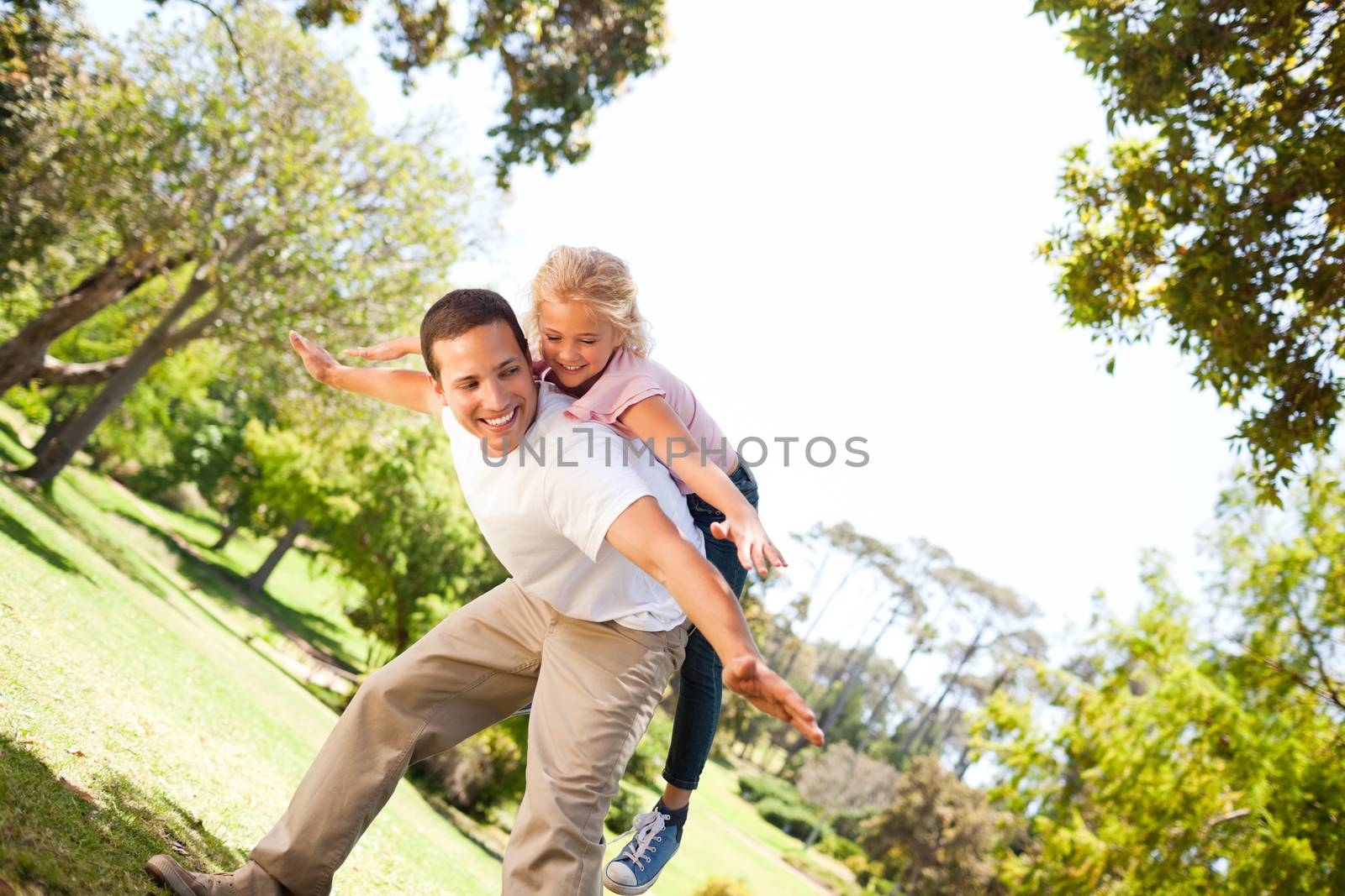 Little girl playing with her father in the park by Wavebreakmedia